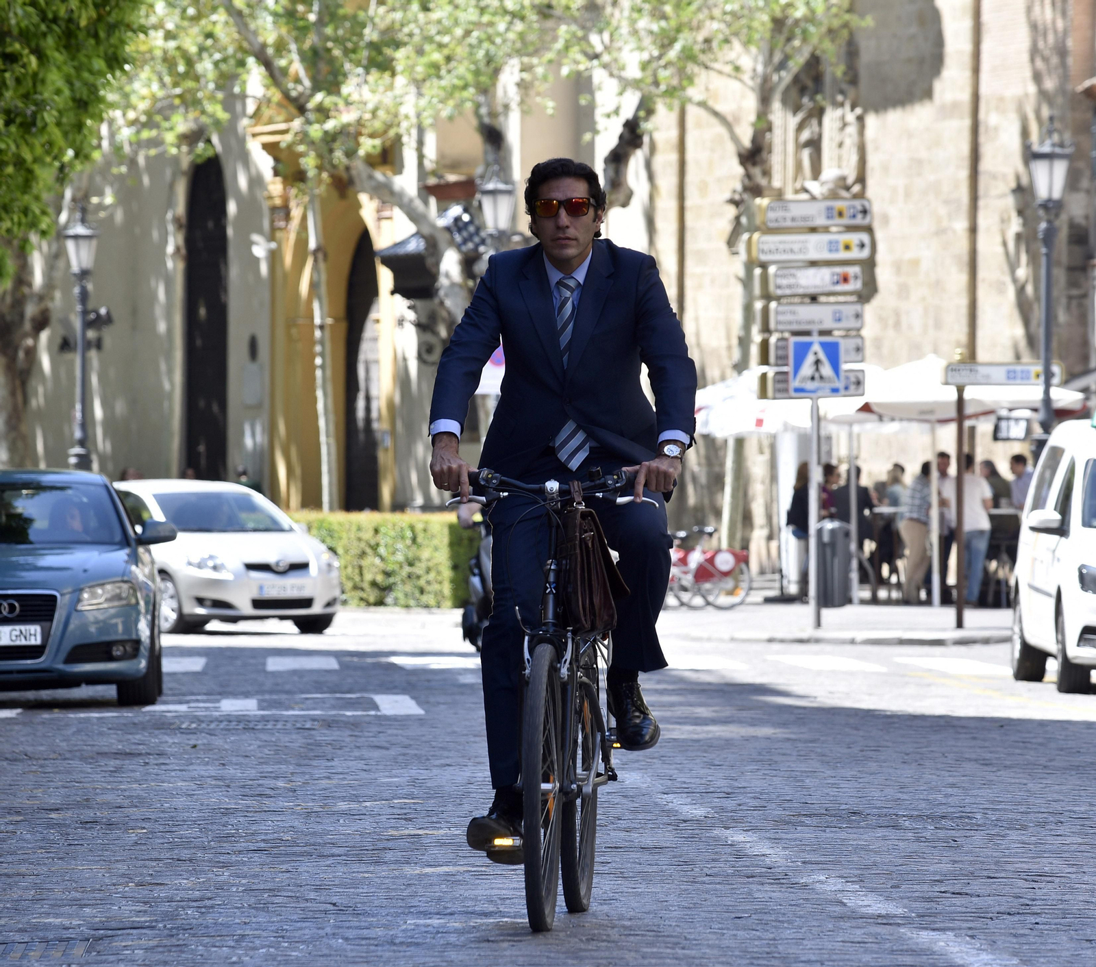 Un trabajador con chaqueta cruza en bici por la Magdalena.