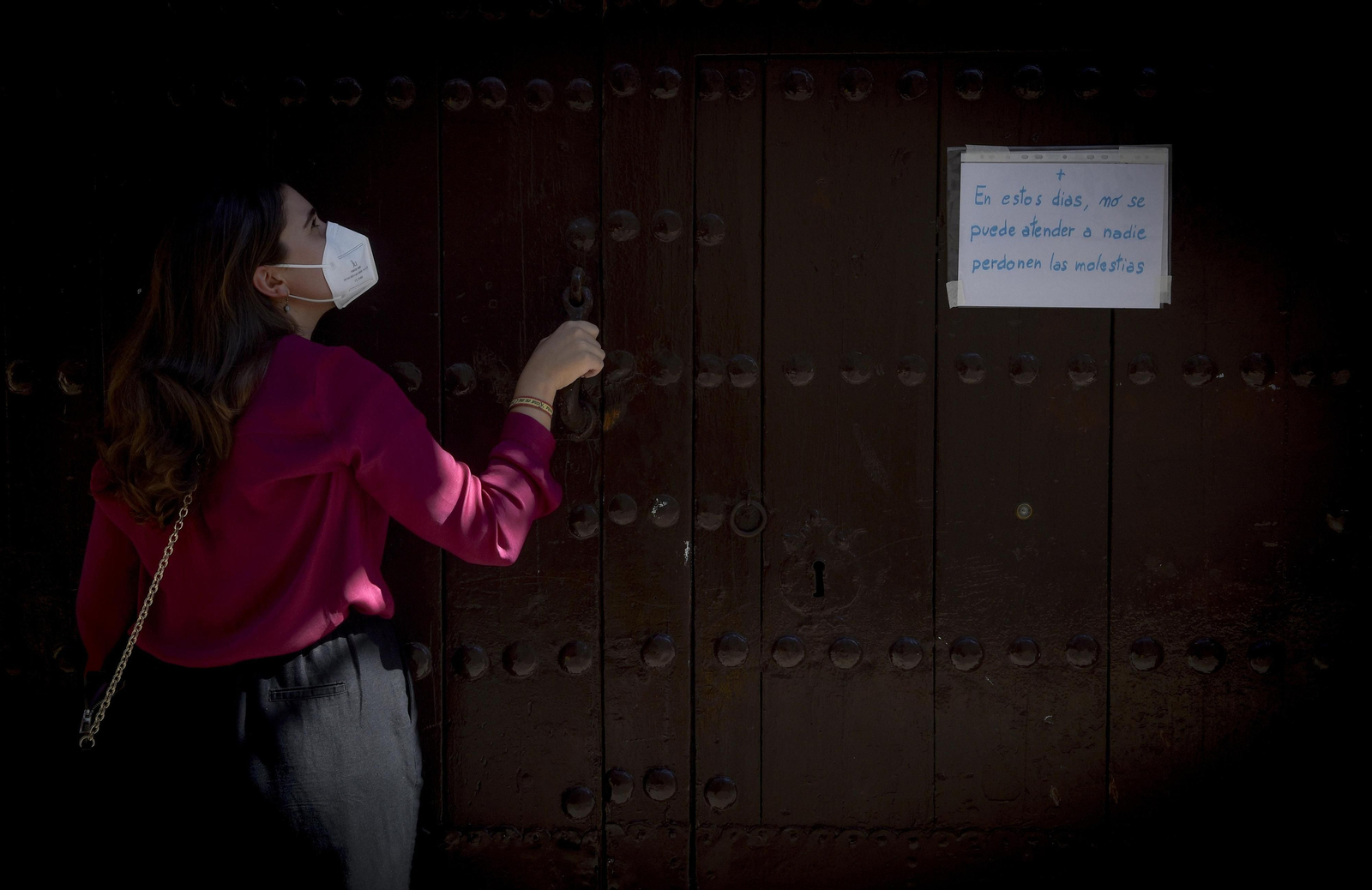 Puerta principal del convento de la calle Santa Ángela de la Cruz, con un cartel que informa del cierre.