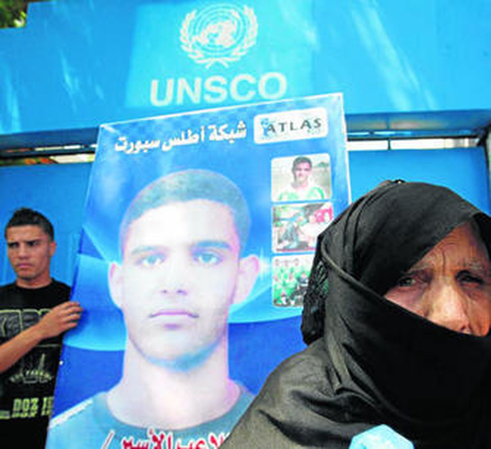Manifestantes portan en Gaza una pancarta con fotos del futbolista Mahmoud Sarsak.