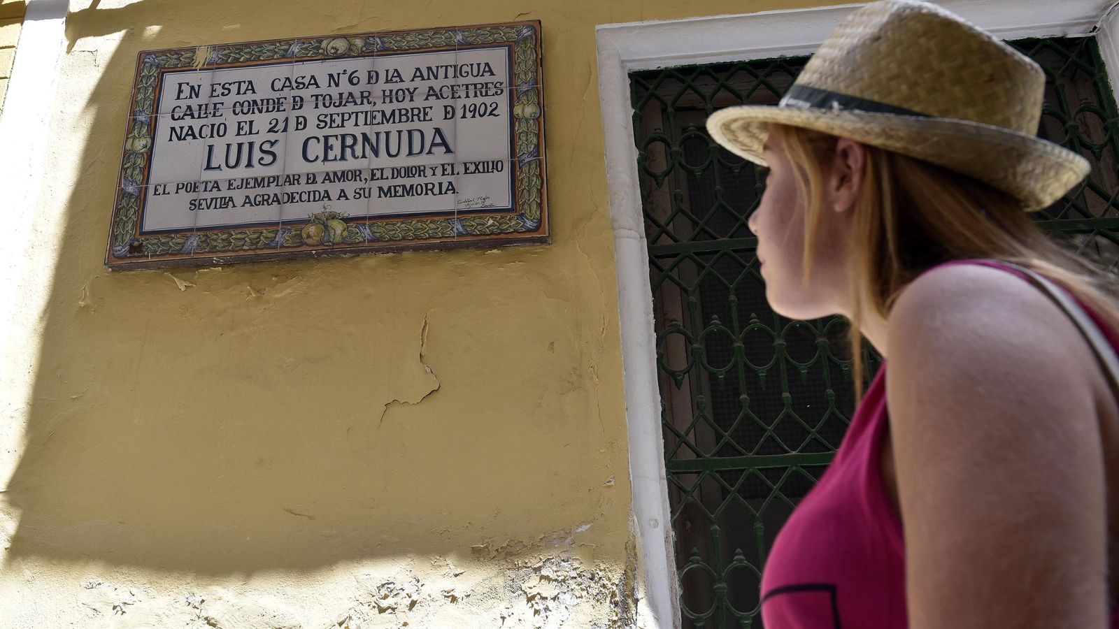 Una joven pasa a la altura de la casa natal de Luis Cernuda, en el número 6 de la calle Acetres.