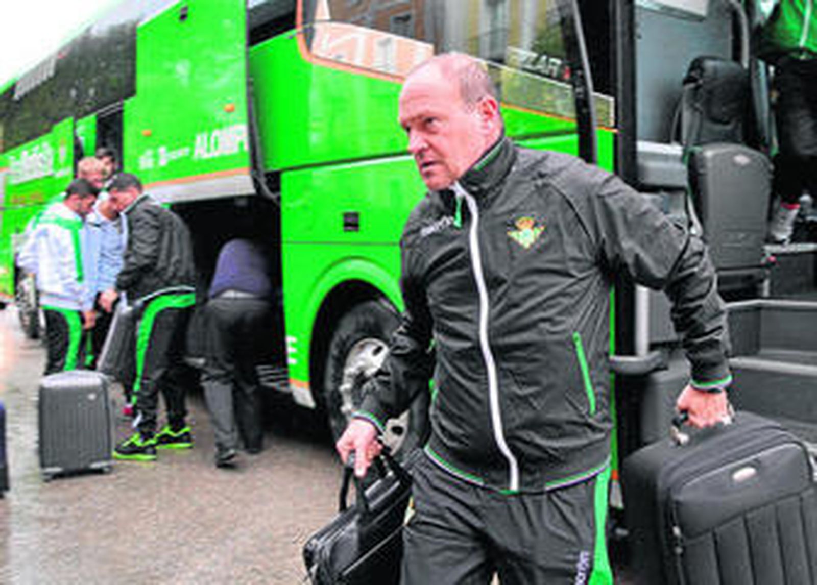 Pepe Mel, cargado con la maleta y el ordenador portátil, se apresura a entrar en el hotel ante la fina lluvia que caía.