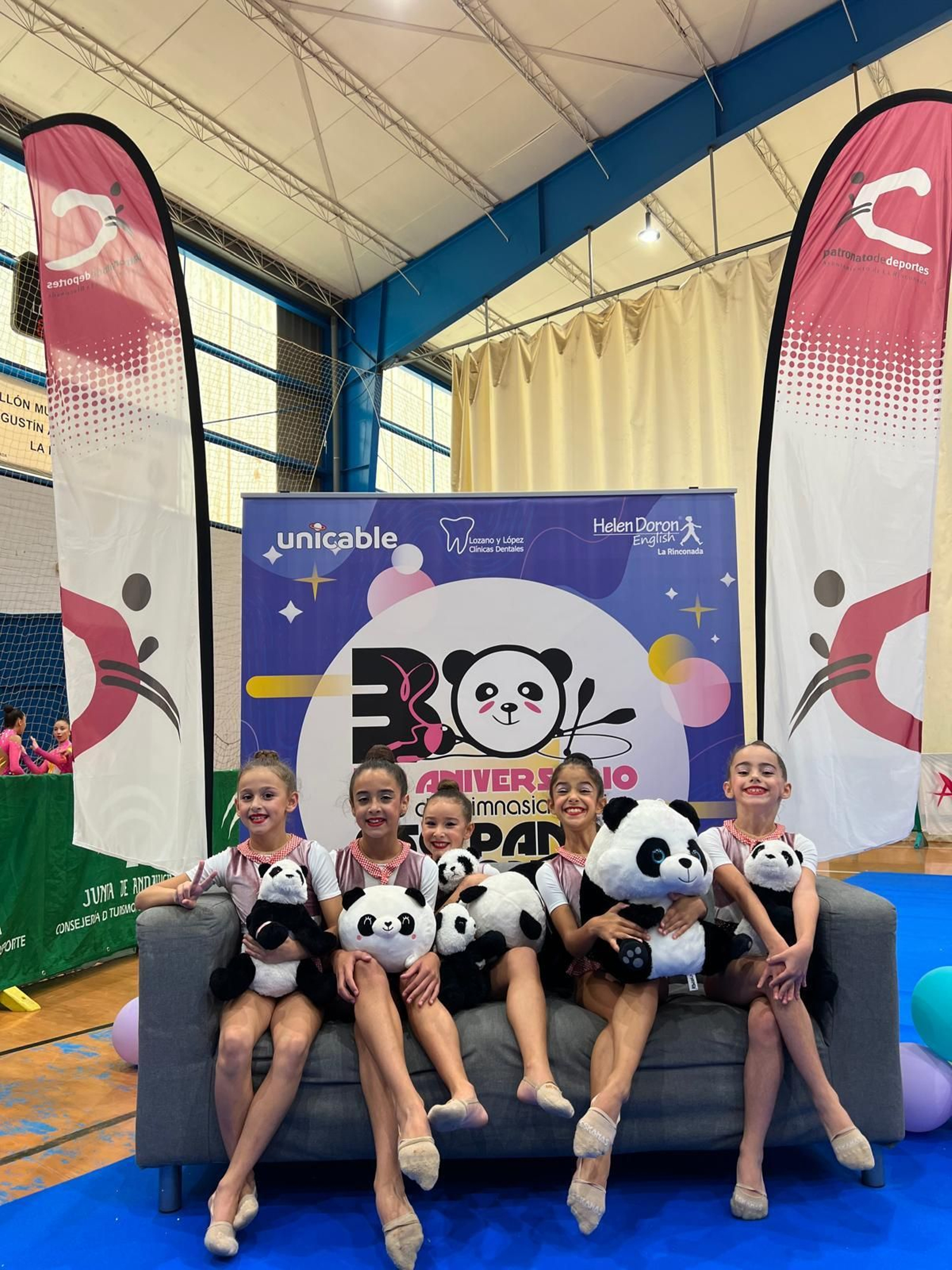 Gimnastas de Huelva posan con osos panda de peluche.