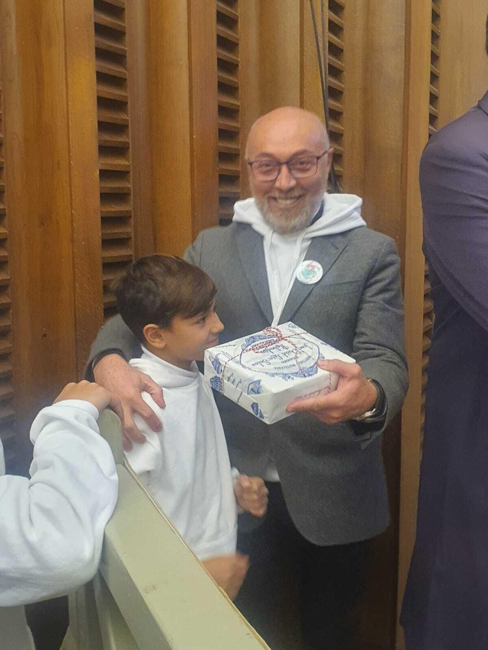 El sacerdote Miguel David Pozo muestra la caja de dulces cordobeses para el Papa.