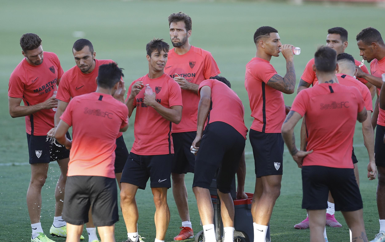 Parte de la plantilla sevillista se hidrata en un entrenamiento de esta misma semana.