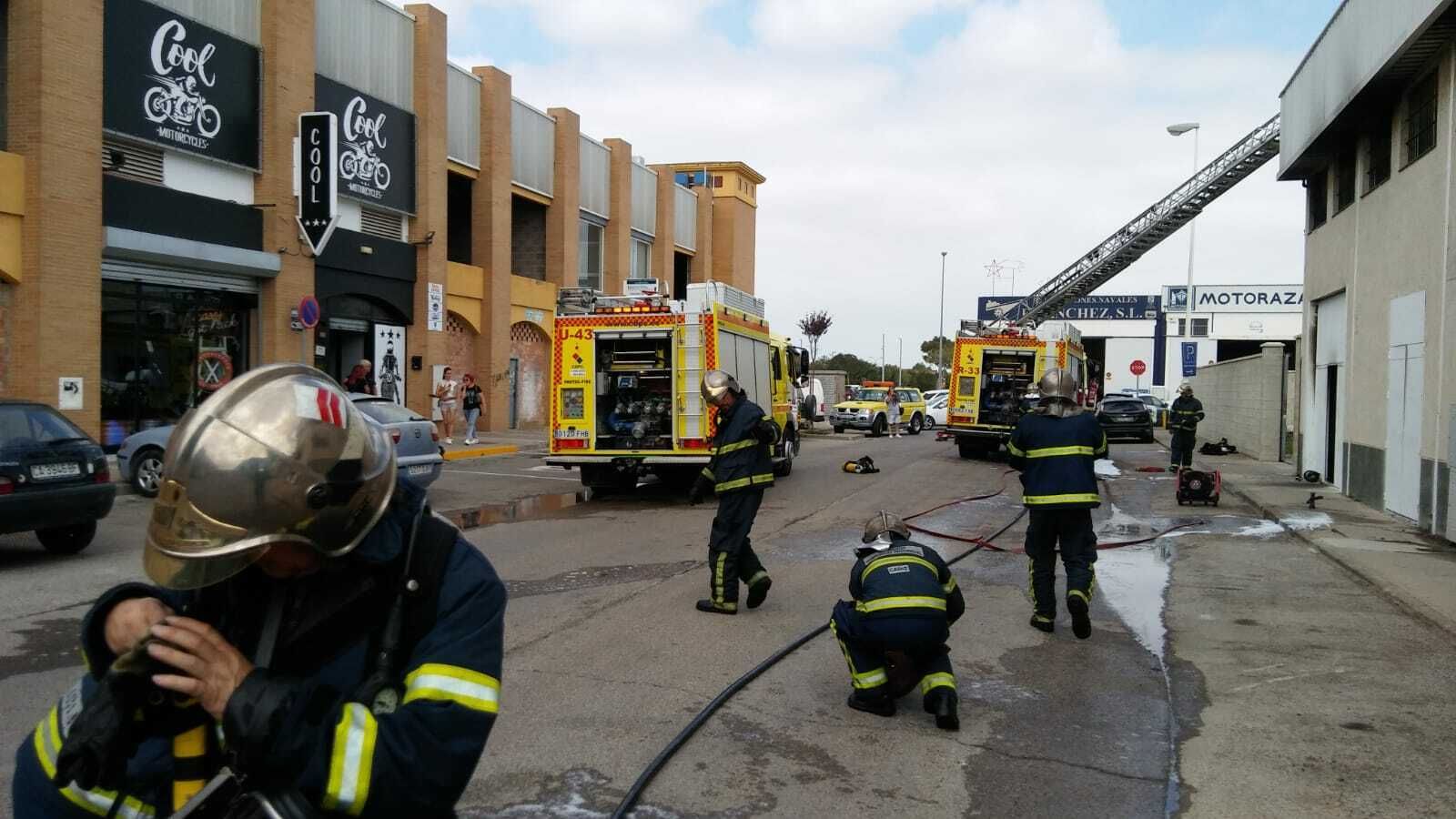 Bomberos en el exterior de la nave durante las labores de extinción del fuego.