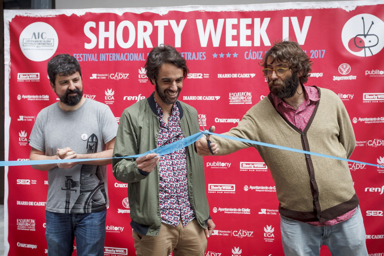 El coordinador de Shorty Week, Mikel Gil, mientras César y Jesús Guisado, de Monkey Week, cortan la cinta inaugural del festival de cortos.
