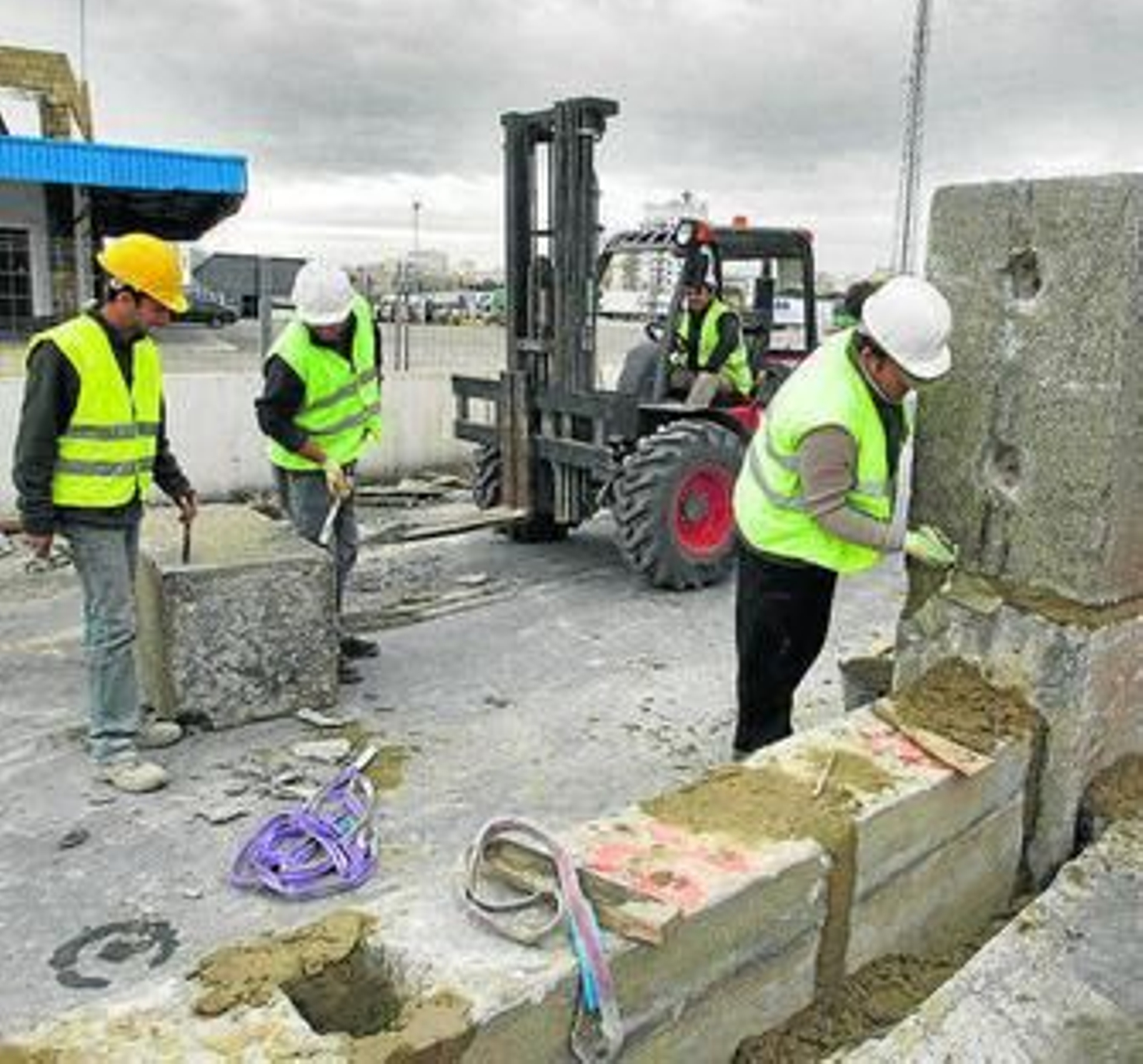 Operarios trabajando ayer en la verja del muelle.