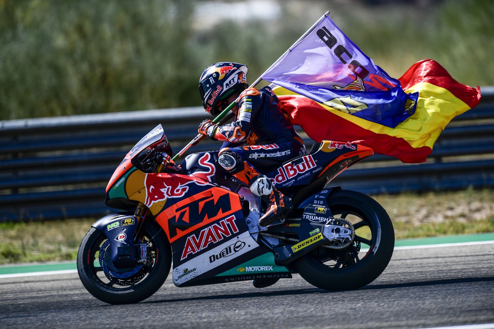 Pedro Acosta porta la bandera de España y otra de su club de fans tras ganar en Aragón.