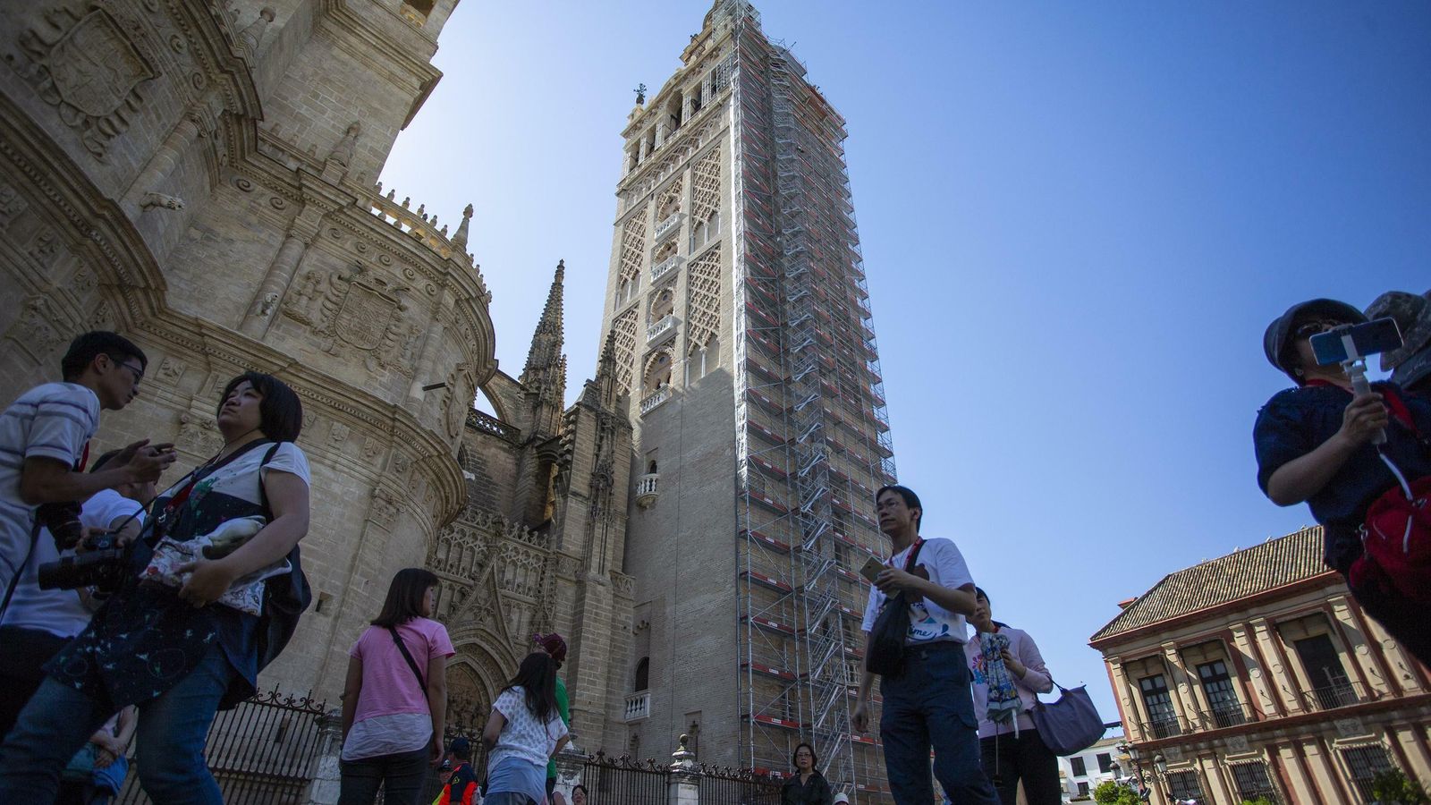 Un grupo de turistas pasea ante la Catedral y la Giralda.