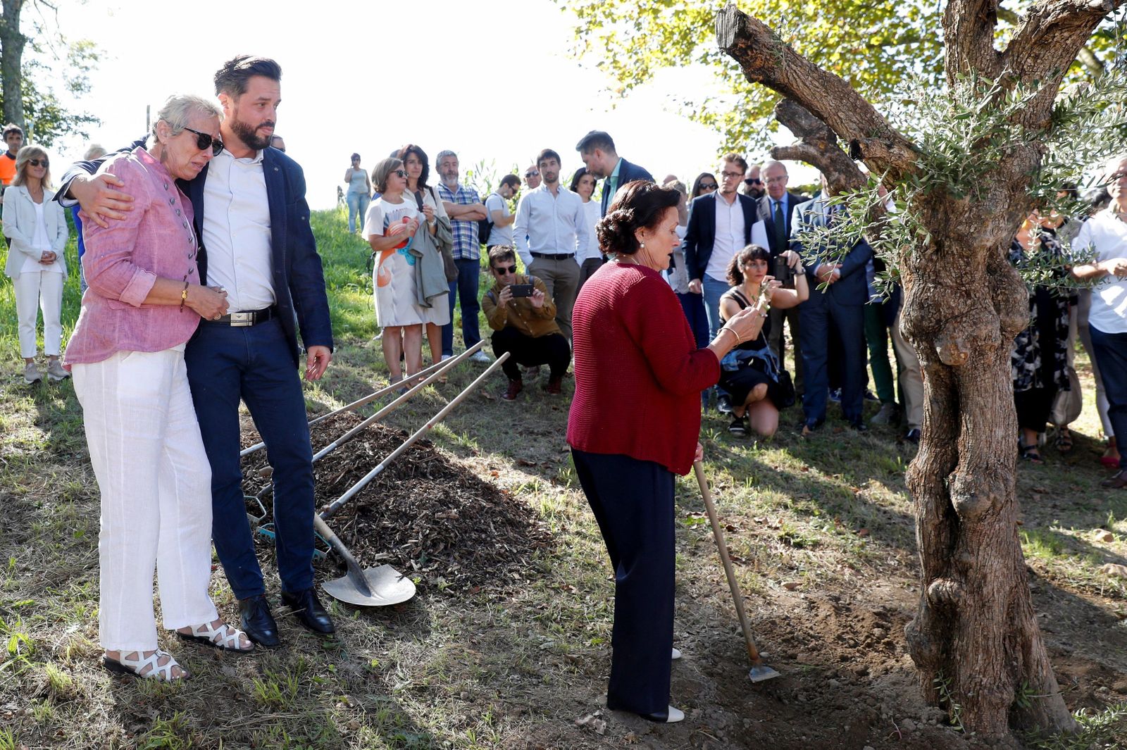 Dolores García y José Miguel Cedillo, viuda e hijo del policía nacional asesinado por ETA, y la hermana del fallecido, María Cedillo, observan un olivo plantado ayer en Errenteria.