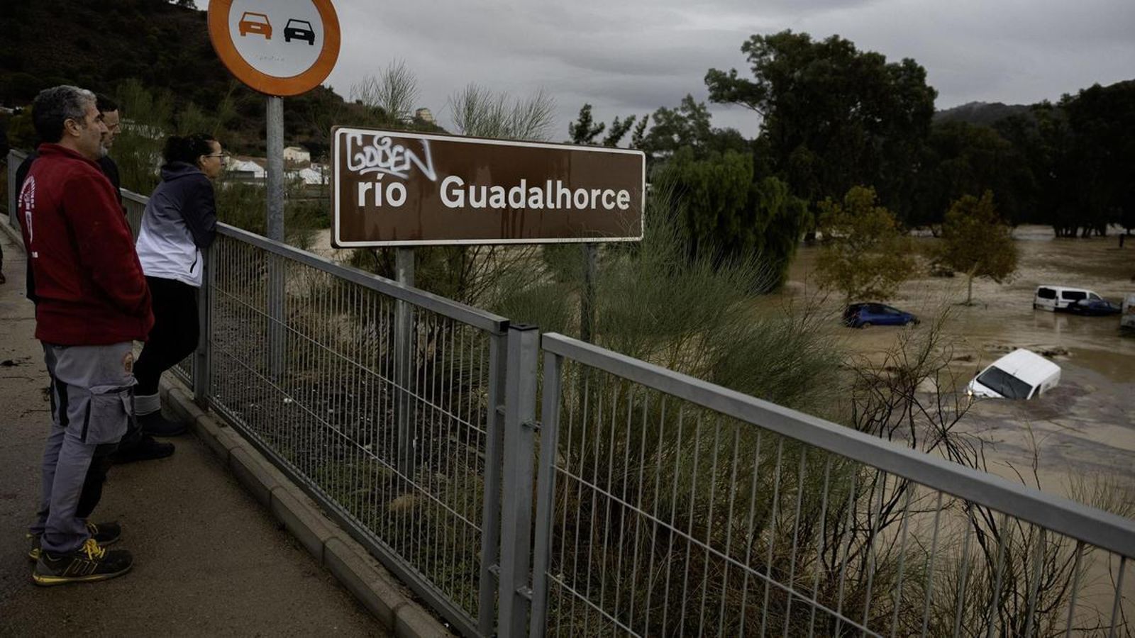Varios vecinos observan varios automóviles varados en el río Guadalhorce (Málaga). Varios vecinos observan varios automóviles varados en el río Guadalhorce (Málaga).