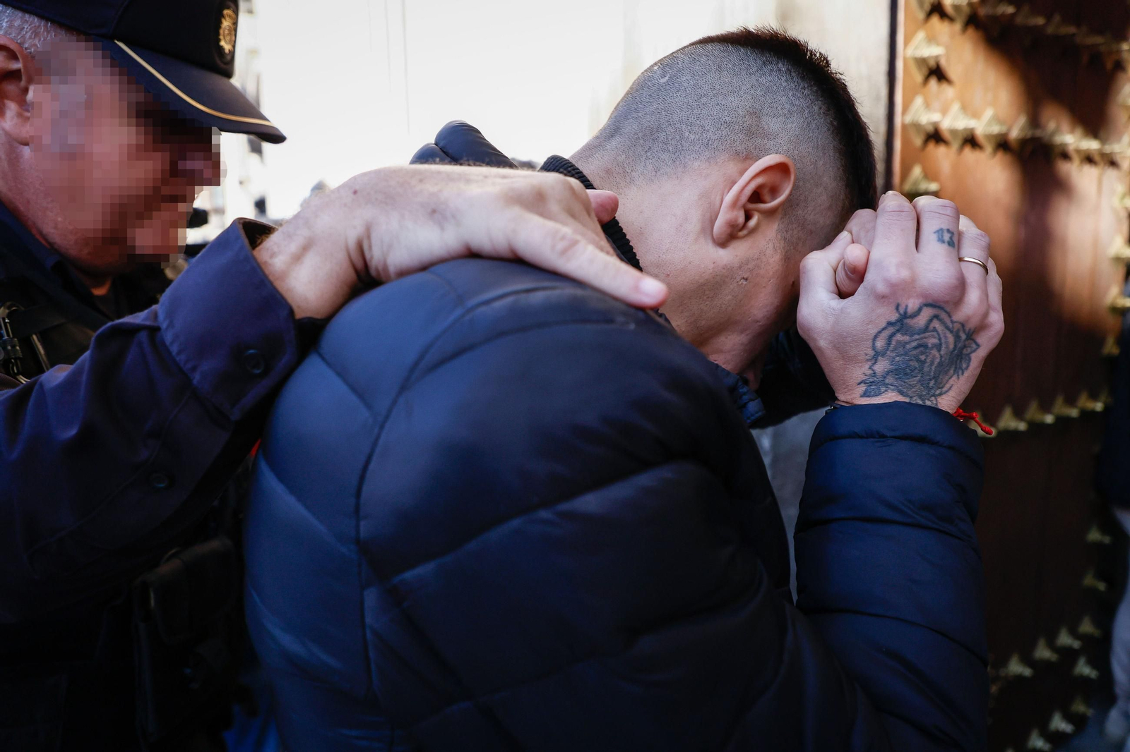 Uno de los acusados se tapa la cara a su entrada a los juzgados.