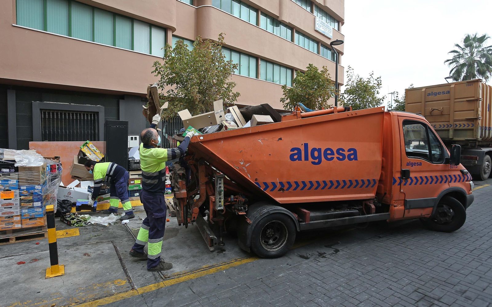 Operarios de Algesa recogen cajas de cartón de la calle.