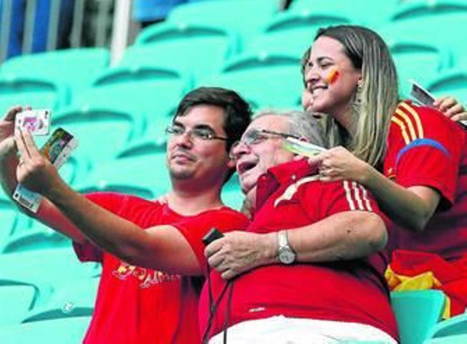 Unos aficionados españoles se toman una foto con un teléfono móvil. Unos aficionados españoles se toman una foto con un teléfono móvil.