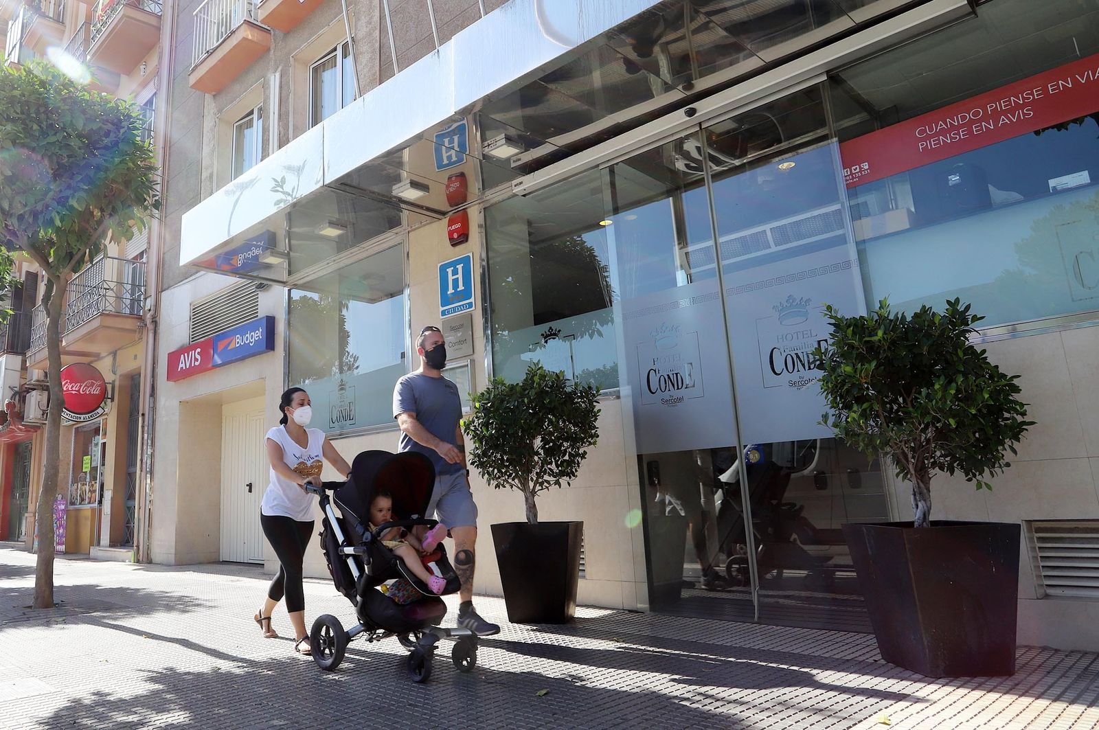 Una familia pasea frente a un hotel de la capital onubense.