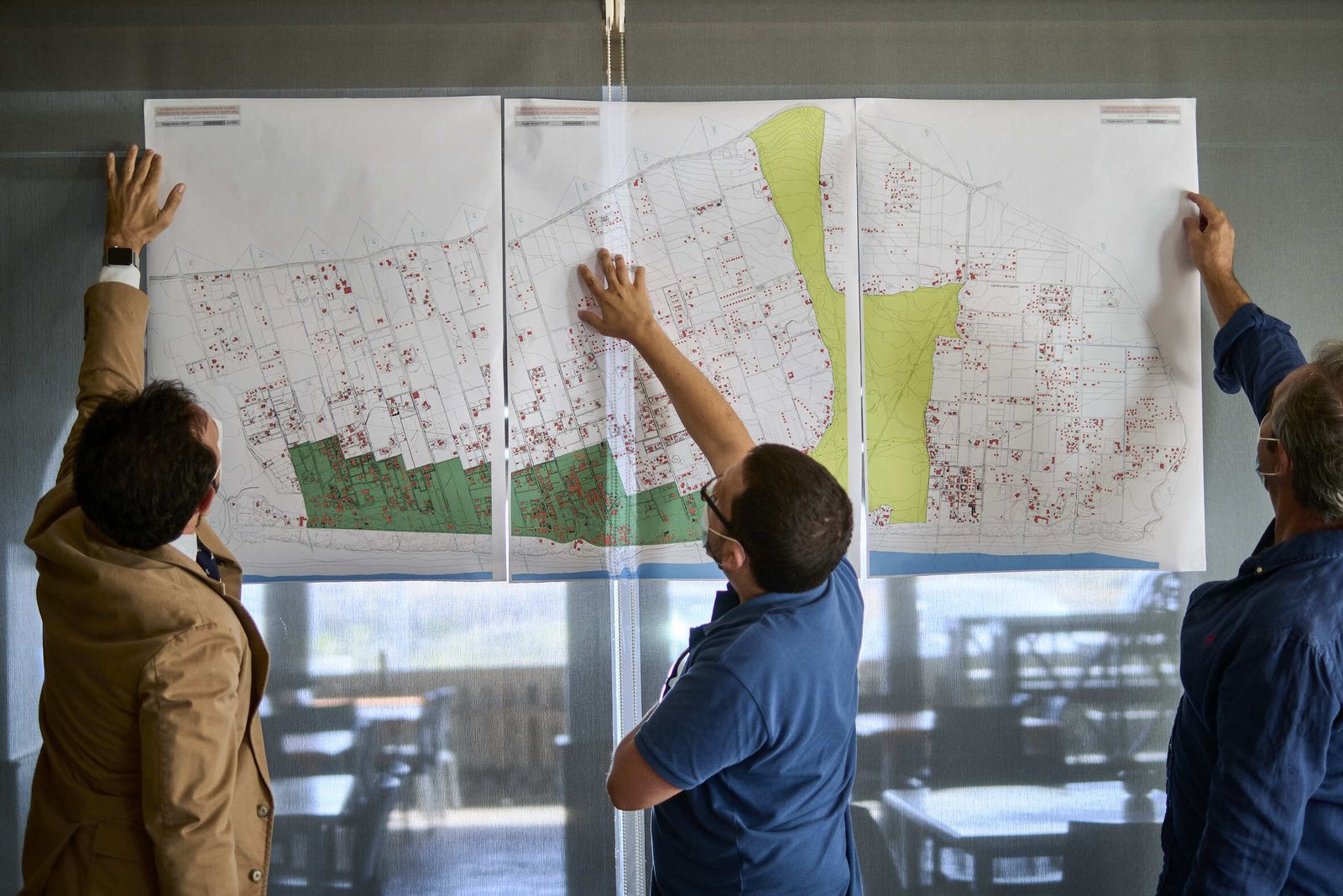 La Plataforma de Afectados por las Viviendas Irregulares de El Palmar mira un mapa de la zona.