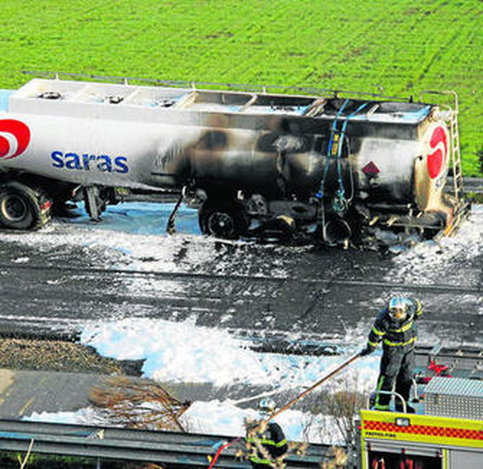 El camión volcado en la A-381, mientras trabajan los bomberos.