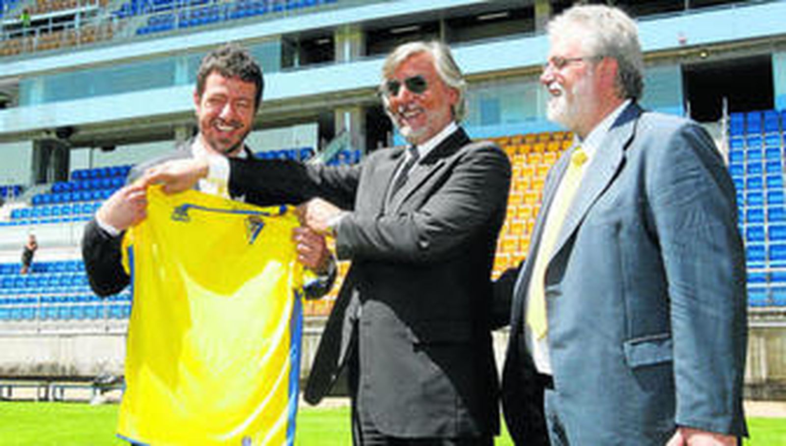 Giovanni del Re (c), uno de los abogados del grupo inversor, coloca la camiseta del Cádiz ante Alessandro Gaucci en presencia de Florentino Manzano.