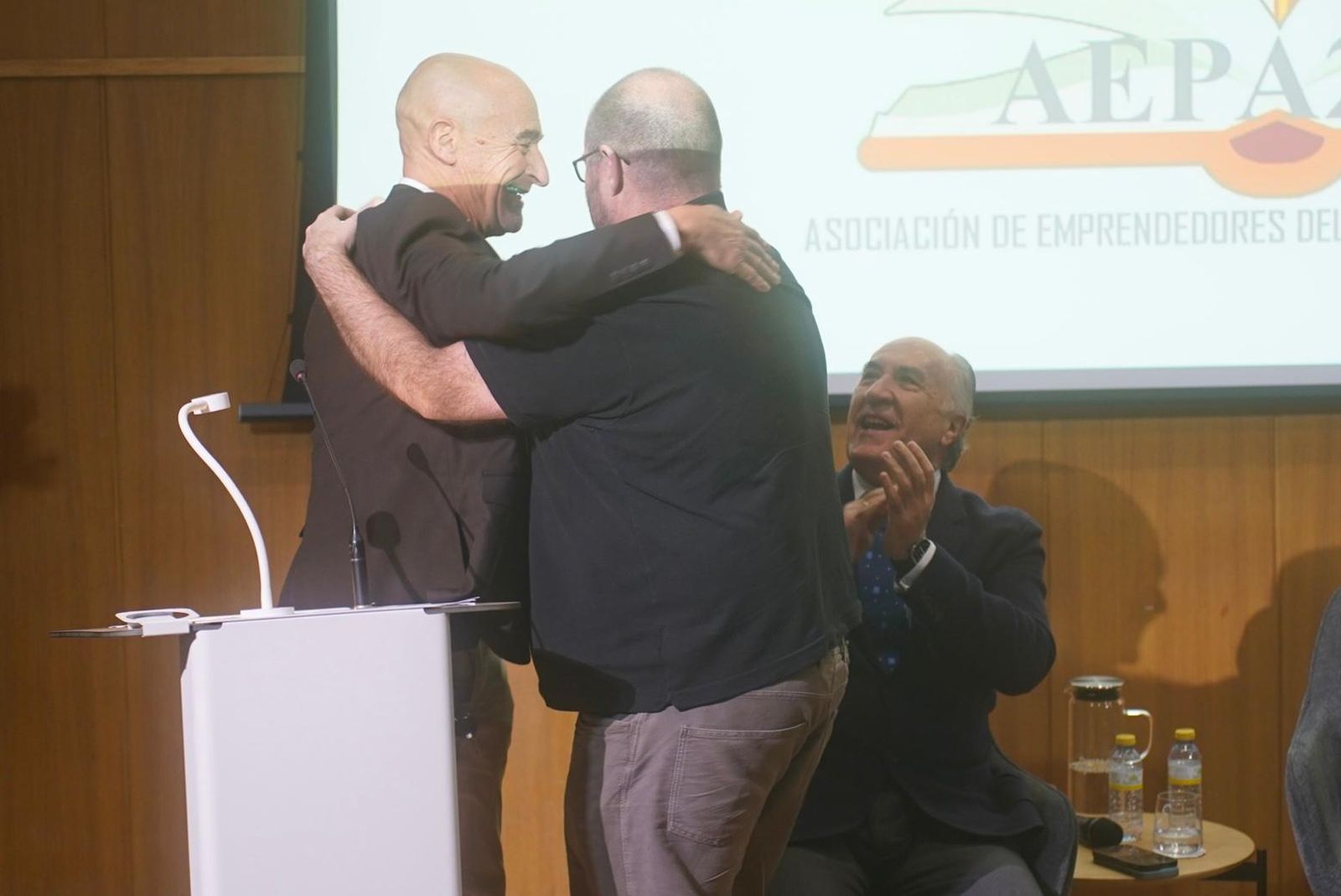 Abrazo entre Ángel Sáez y Asier Unciti-Broceta, con el alcalde José Ignacio Landaluce celebrando el discurso del profesor.