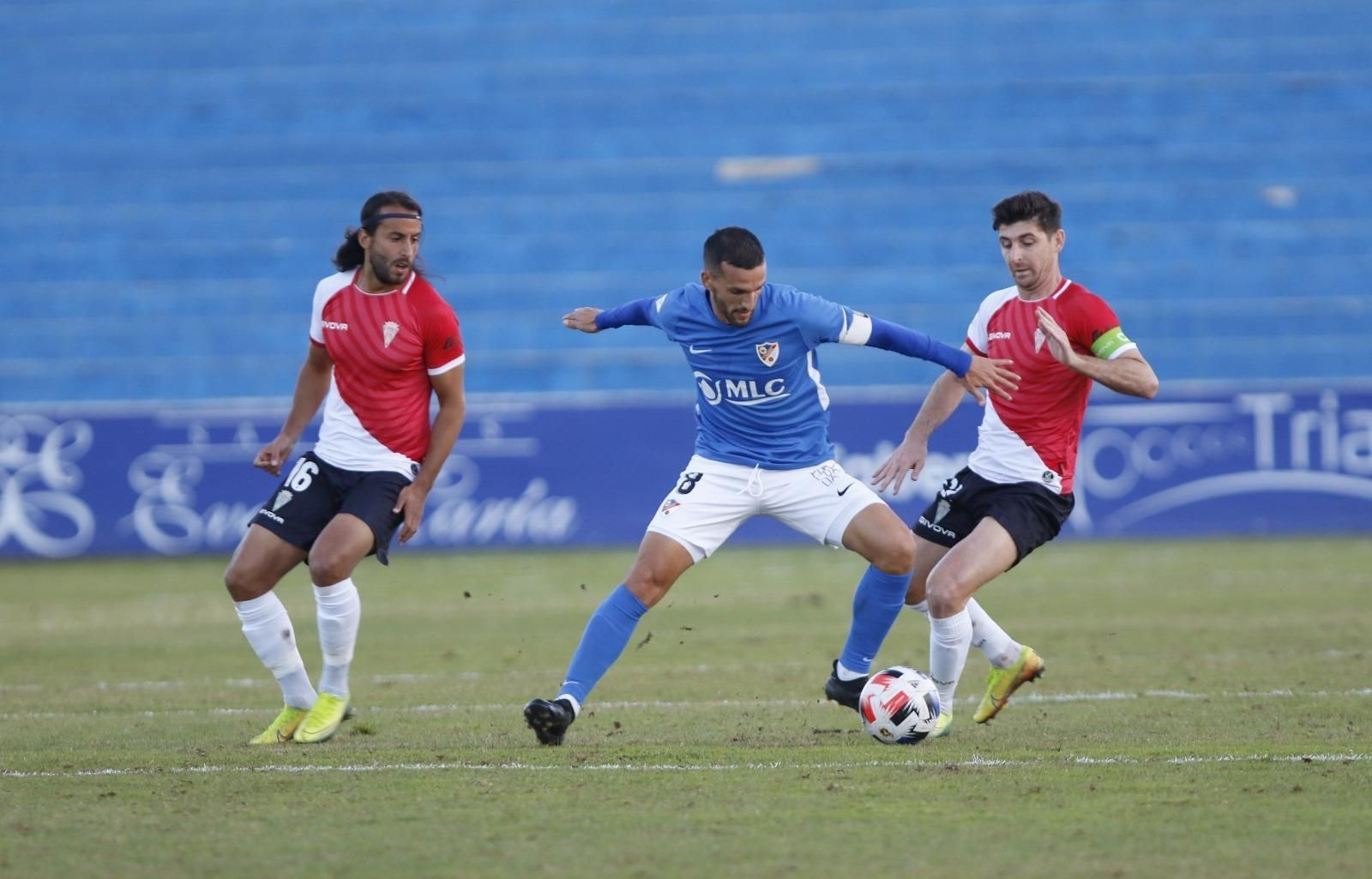 Los cordobesistas, Mario Ortiz y Javi Flores, disputan un balón con el jugador del Linares, Rodri.