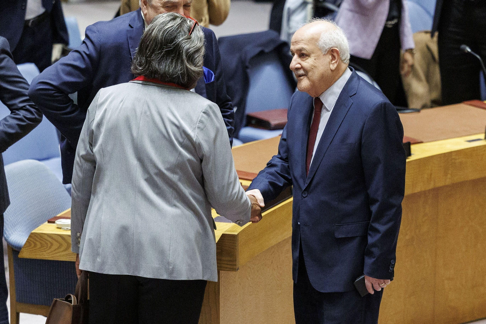 El embajador palestino Riyad Mansour le da la mano a su homóloga de Estados Unidos Linda Thomas-Greenfield  en la ONU.