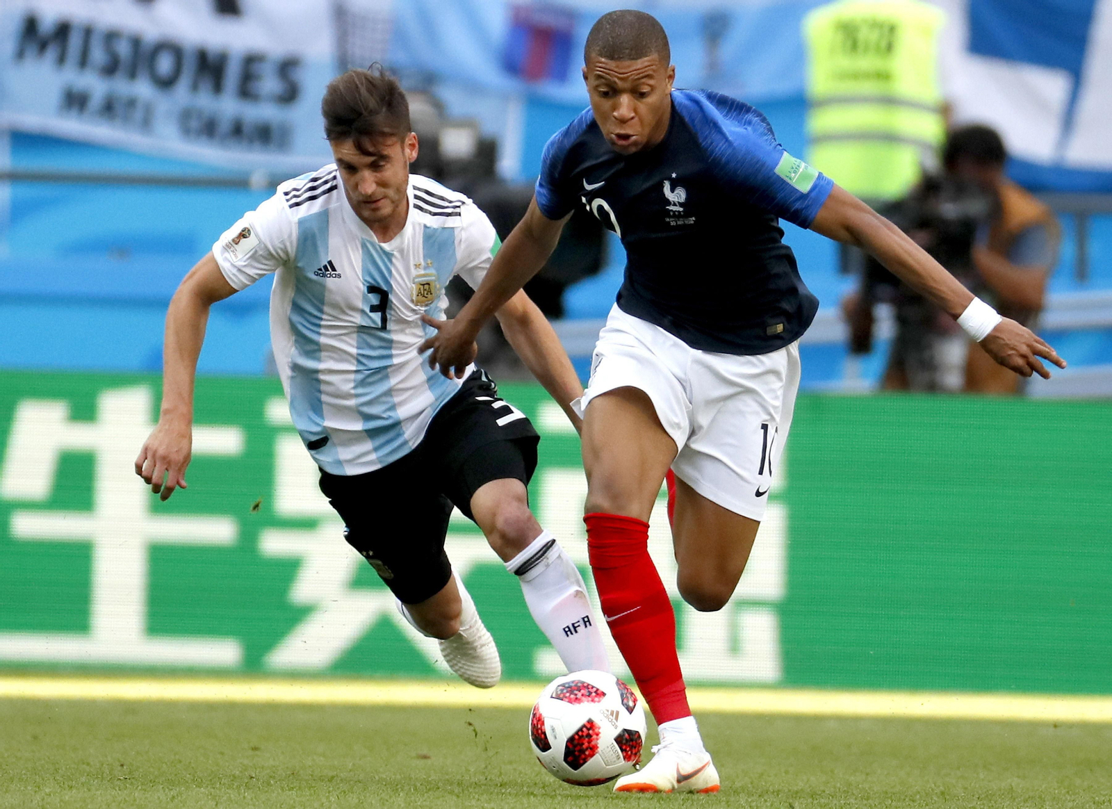 Mbappe cabalga con Tagliafico detrás de él.