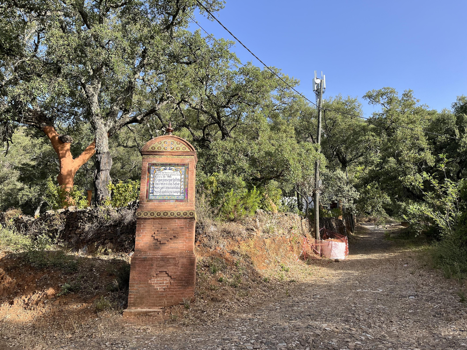 Monolito y azulejo en septiembre de 2023 con el camino de subida a La Peña.