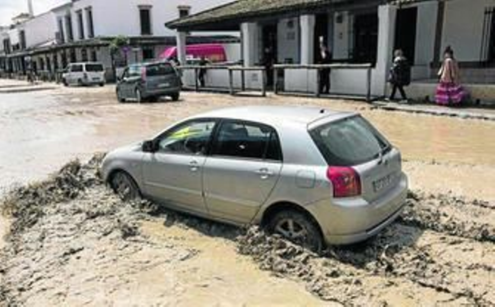 Un vehículo se abre paso por una de las calles de la aldea de El Rocío, anegada de agua.