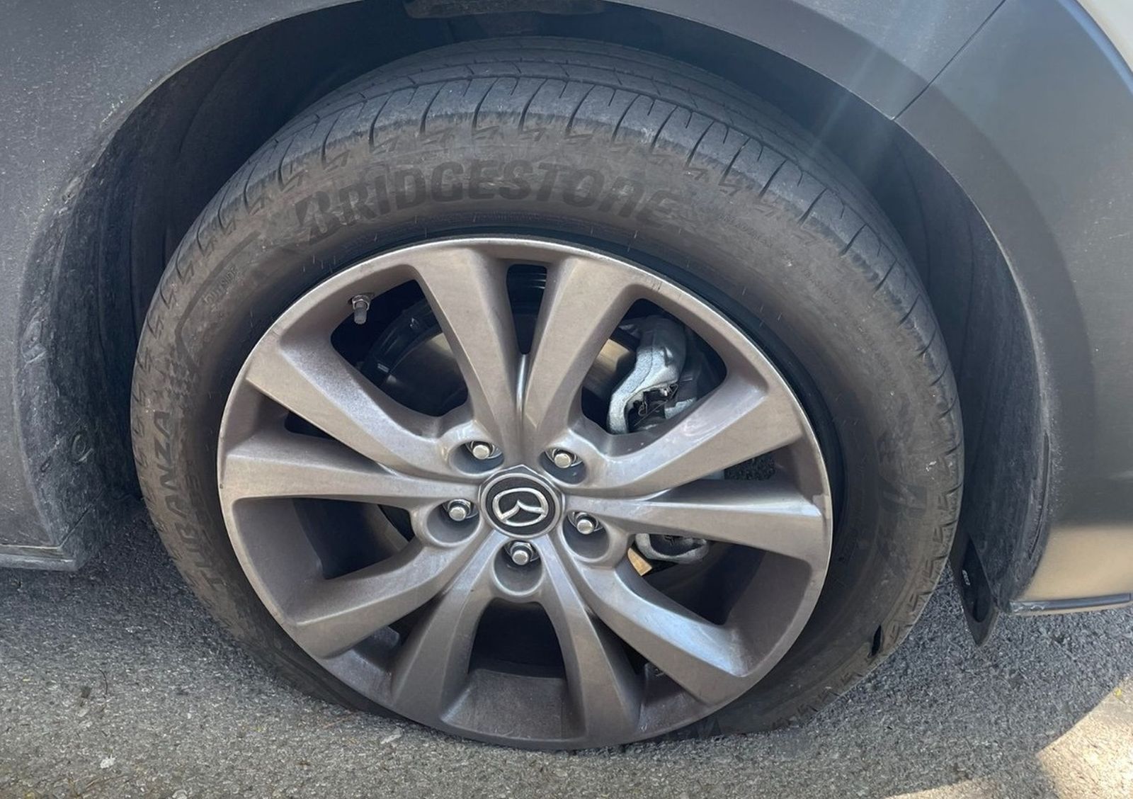 Una de las ruedas del coche vandalizado, rajada y pinchada.