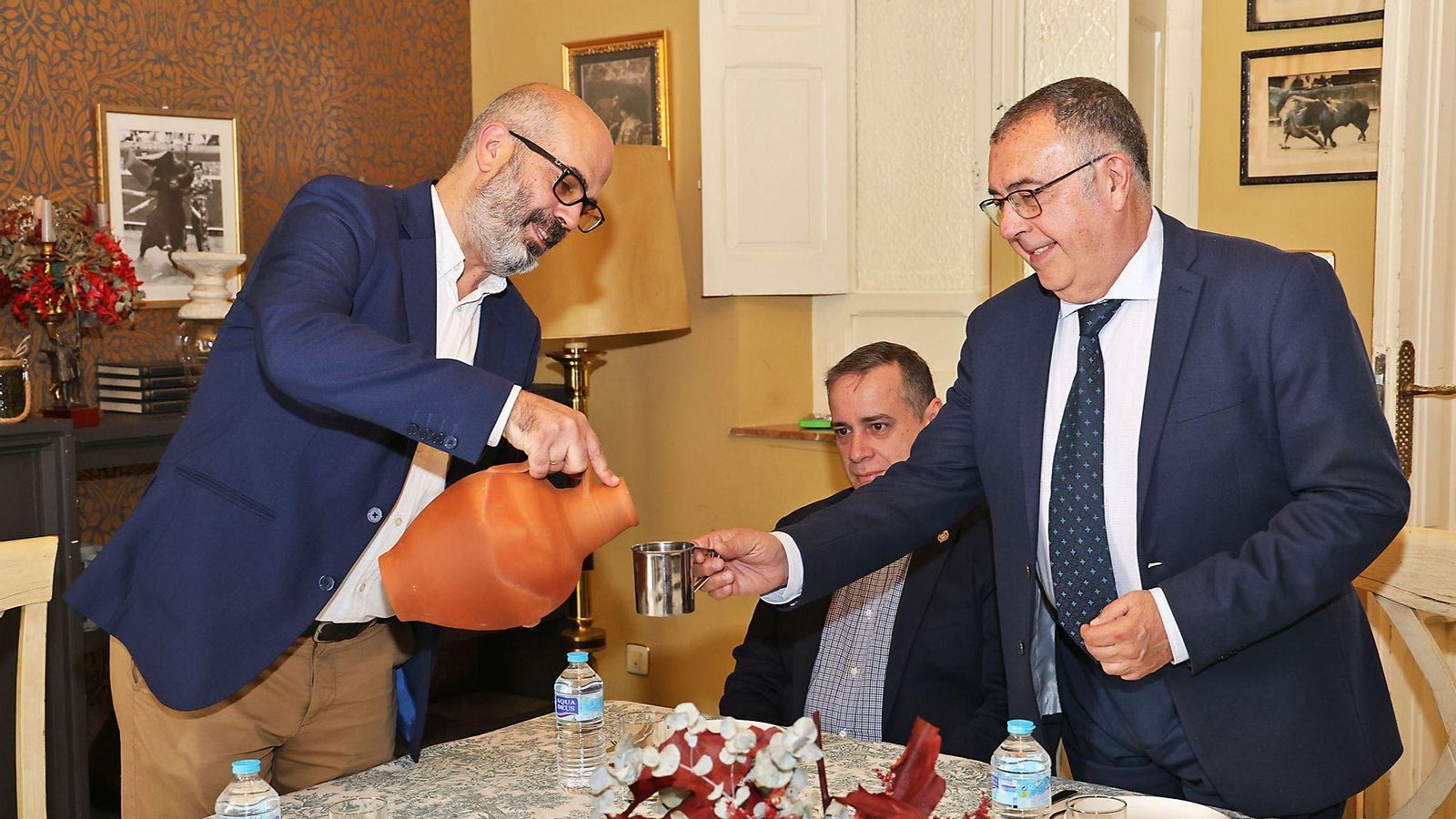 Javier Ronchel, director de Huelva Información, cumple con la tradición de la tertulia y sirve agua del botijo a Manuel Gómez Beltrán