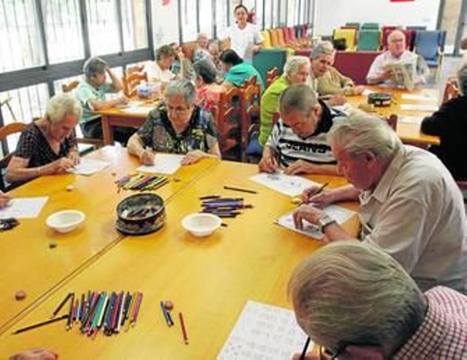 Varios mayores realizan actividades en la sala de ocio para mejorar sus habilidades cognitivas.