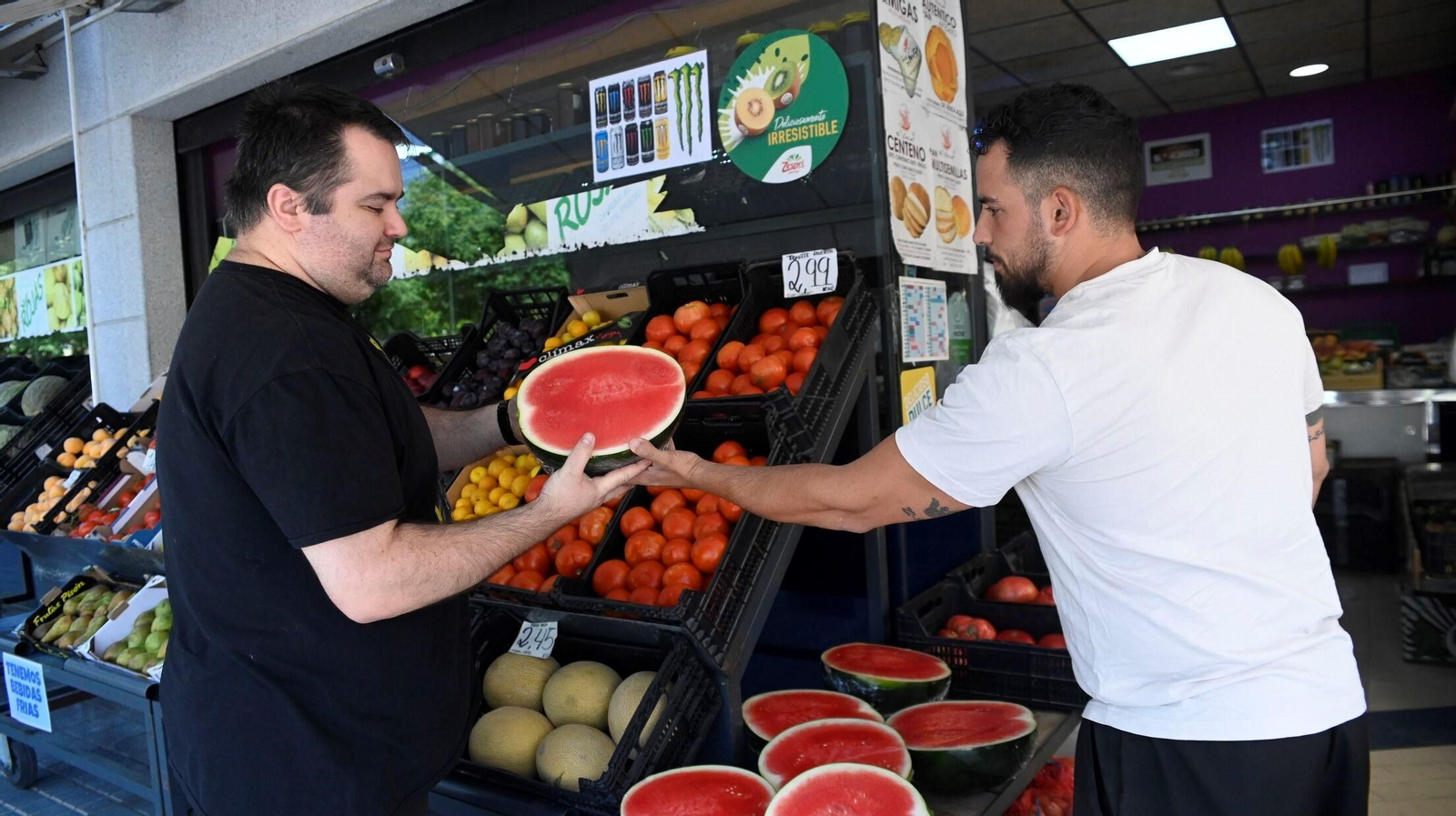 Álvaro Ramos entrega media sandía a un cliente en la Frutería Rojas.