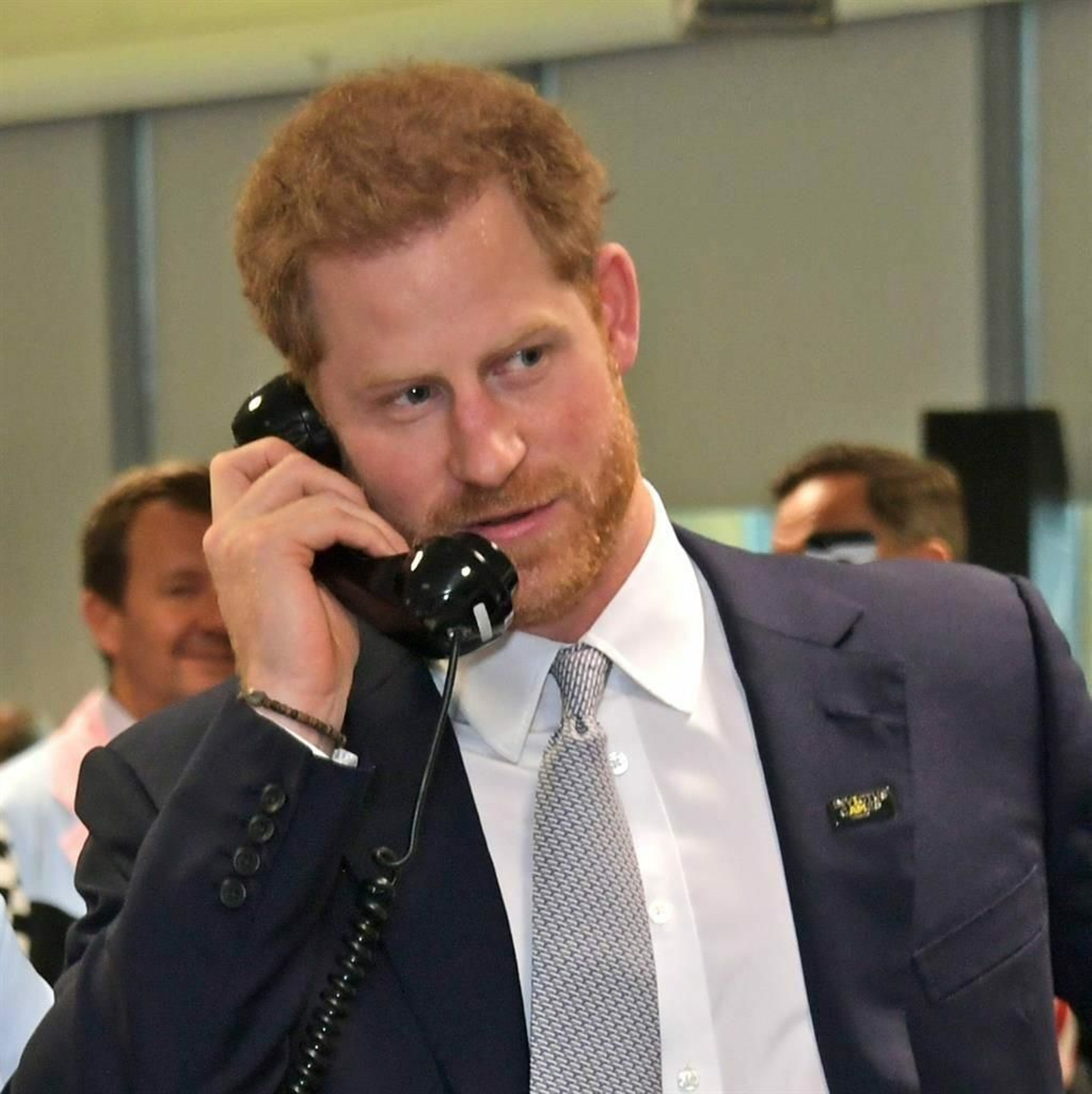 El príncipe Enrique, al teléfono, en un acto público.
