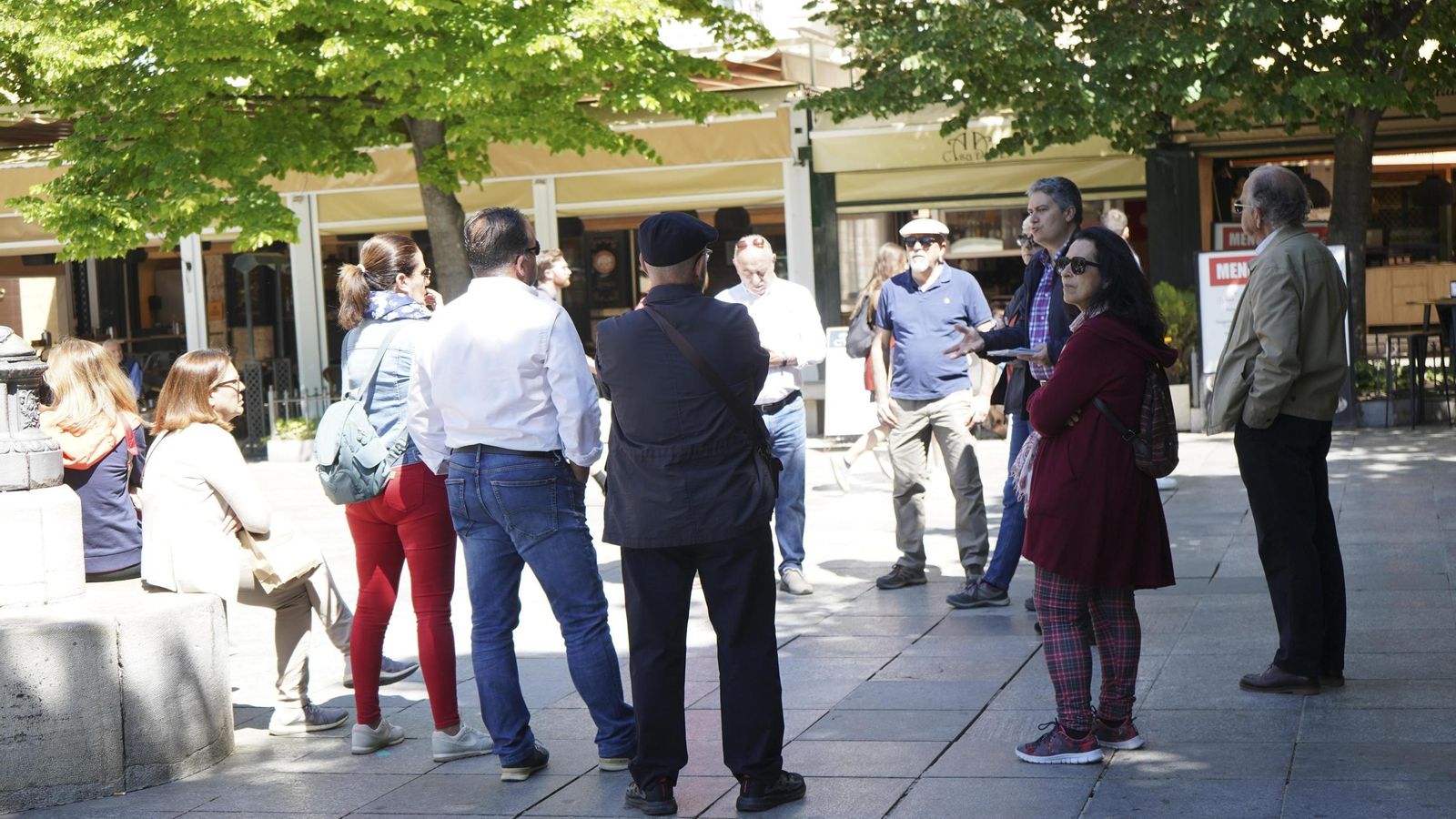 Un grupo de turistas escucha a su guía en la Plaza Bib-Rambla de Granada
