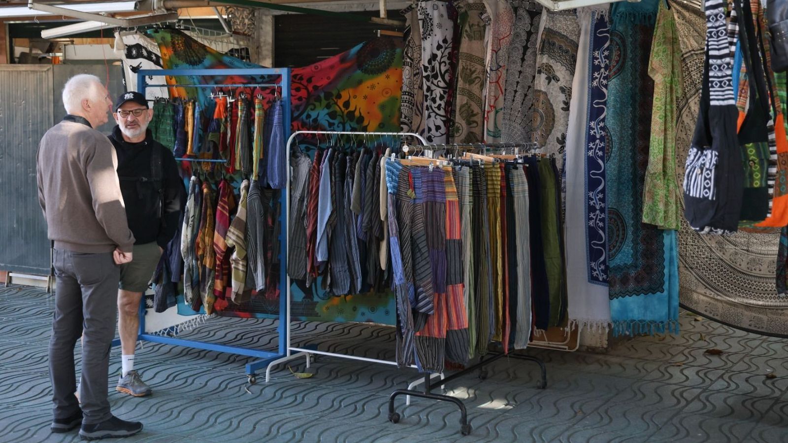 Dos clientes conversan cerca de los puestos de venta.