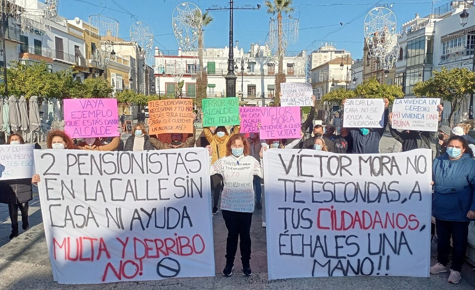 La familia afectada, con vecinos de La Algaida, protestando en la céntrica Plaza del Cabildo.