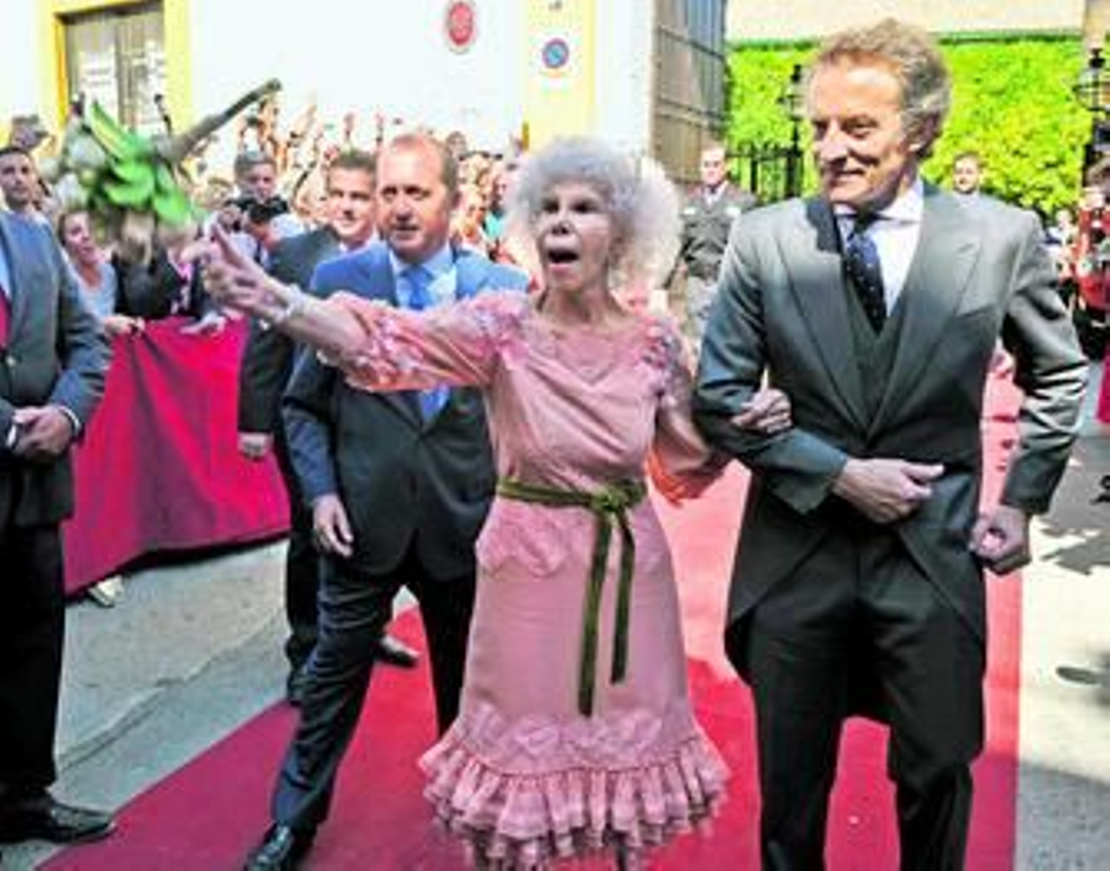 l Cayetana de Alba arroja su ramo de novia al presentarse en las puertas del palacio de las Dueñas del brazo de su ya marido, Alfonso Díez.