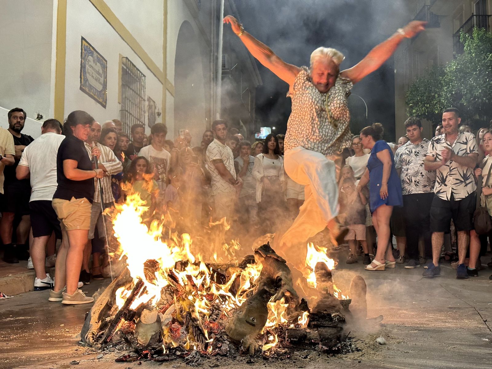 Una mujer saltando una hoguera de San Juan en Arroyo de la Miel.