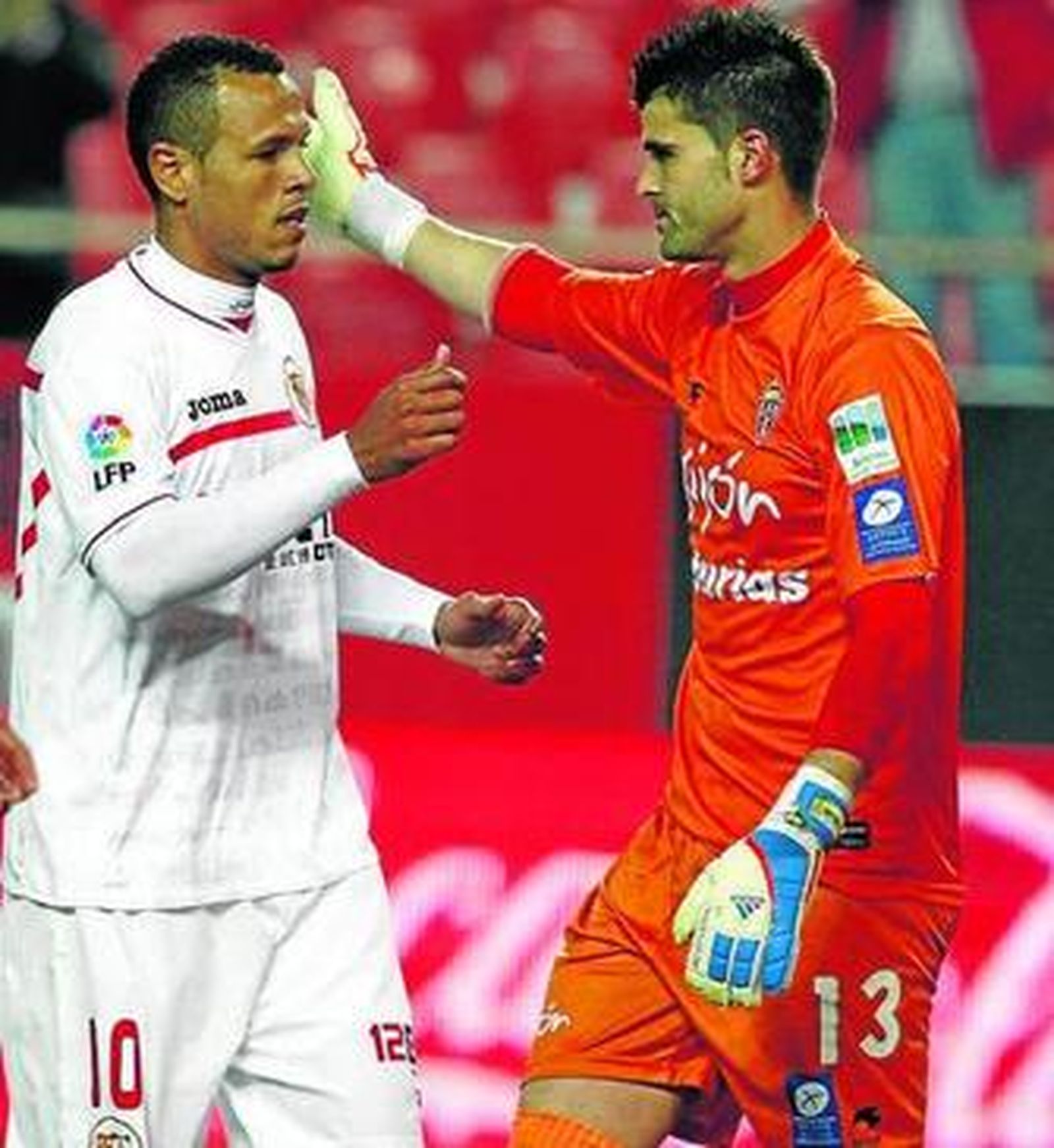 Luis Fabiano dialoga con Cuéllar tras marcar el penalti.