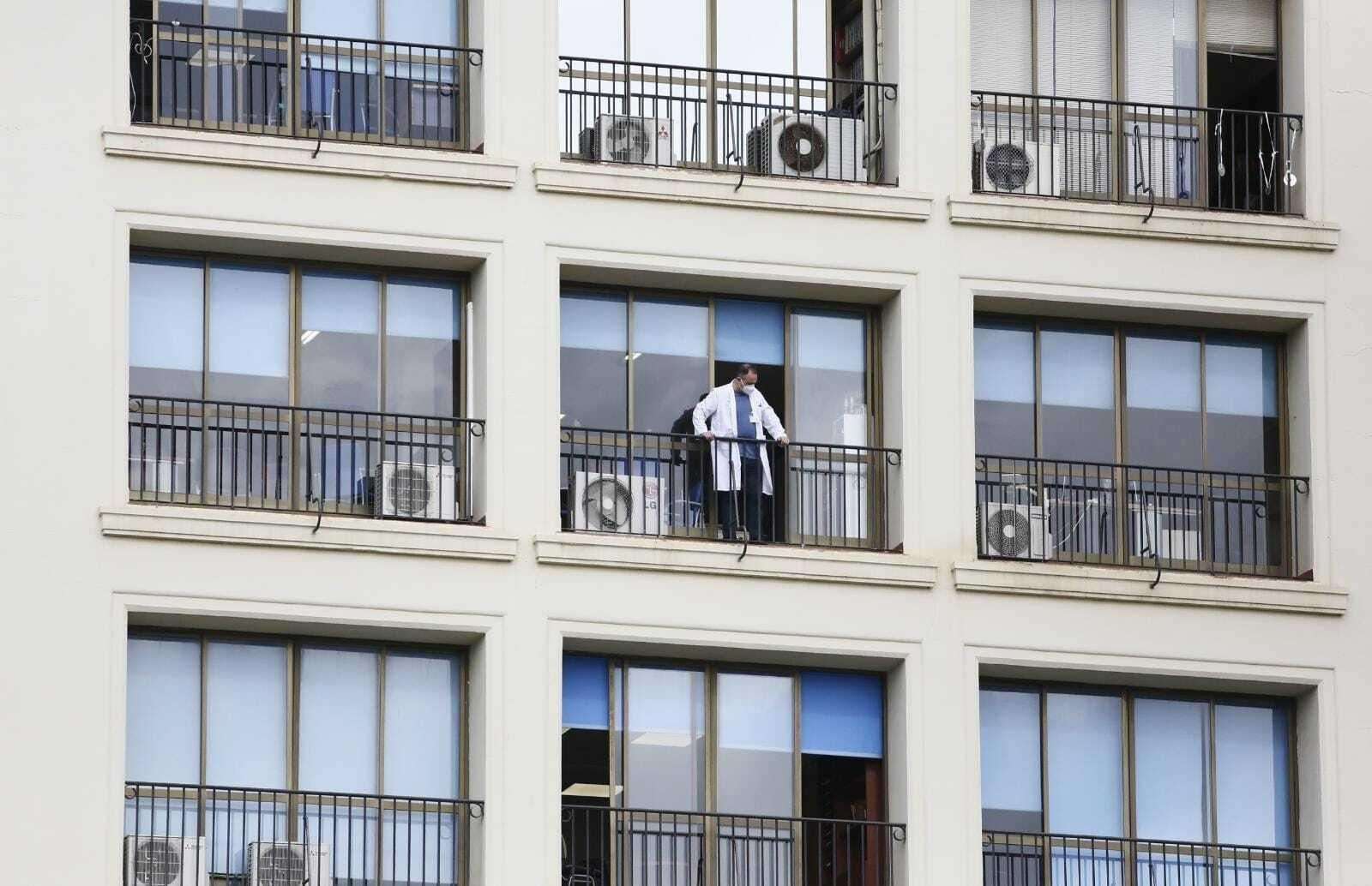 Un sanitario se asoma por el balcón de un centro hospitalario de Málaga