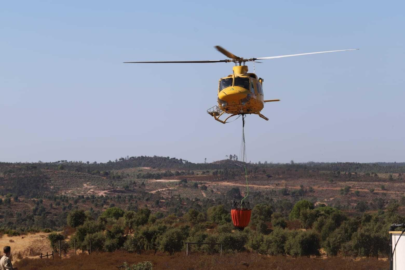 Un helicóptero carga agua para las labores de extinción.