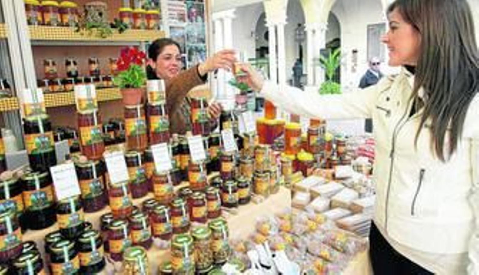 Una de las expositores muestra un tarro de miel.