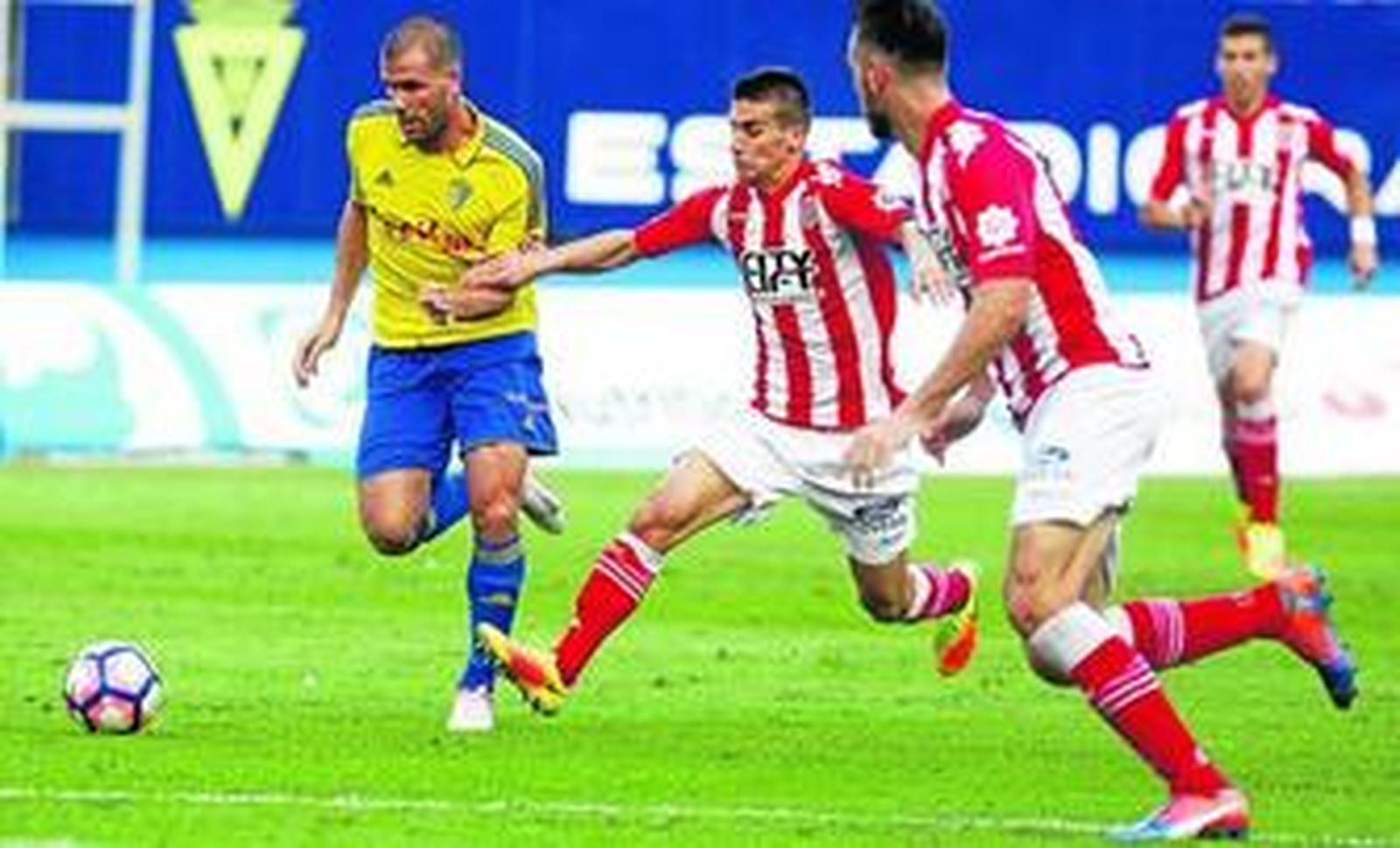 Ortuño trata de librarse de dos jugadores del Girona durante el encuentro contra el conjunto catalán.