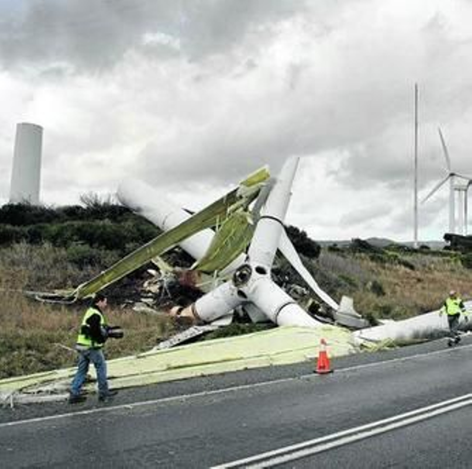 Imagen del aerogenerador destrozado junto a la ladera y la base, al fondo a la izquierda, ayer a mediodía.