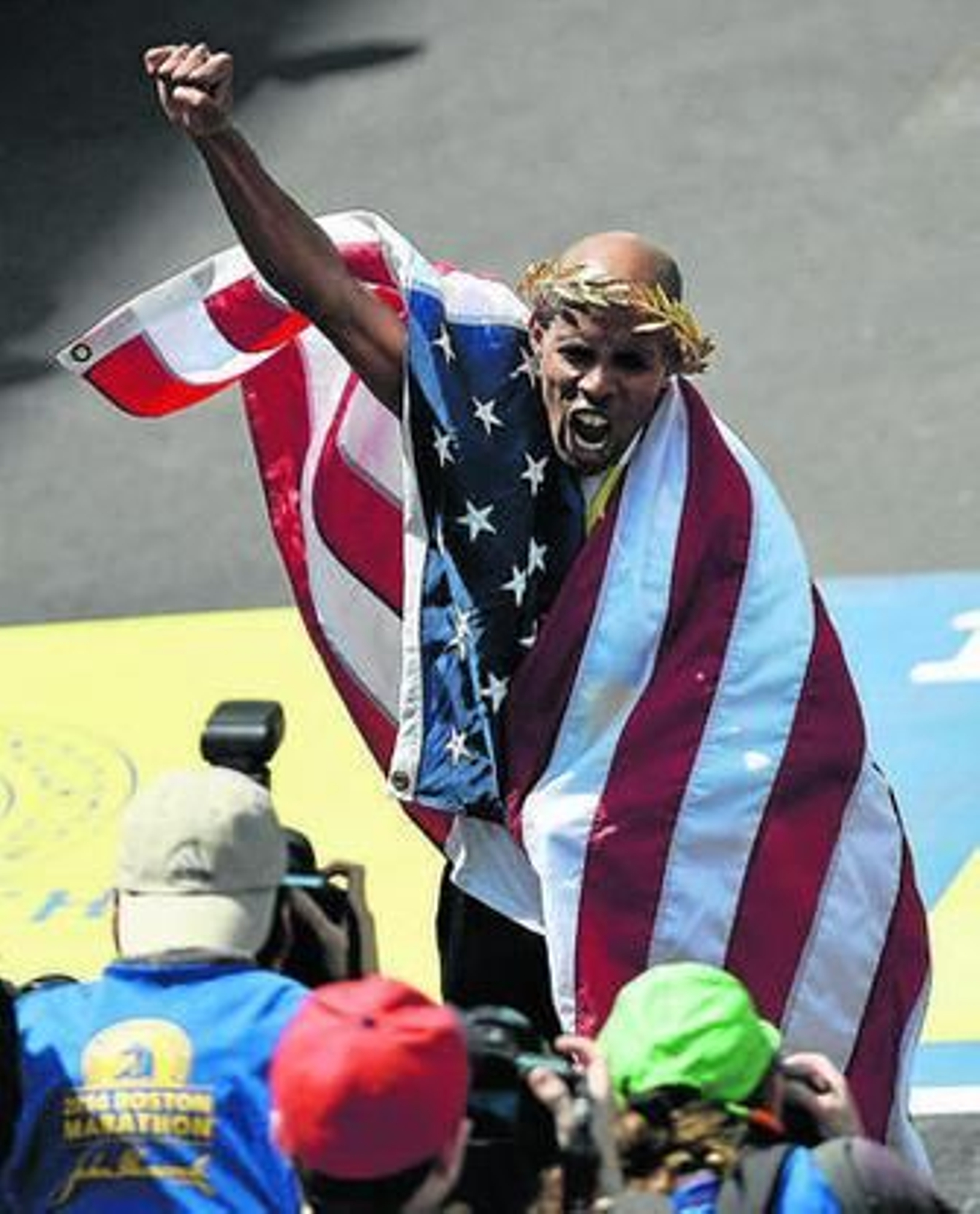 Keflezighi grita eufórico con una bandera estadounidense.