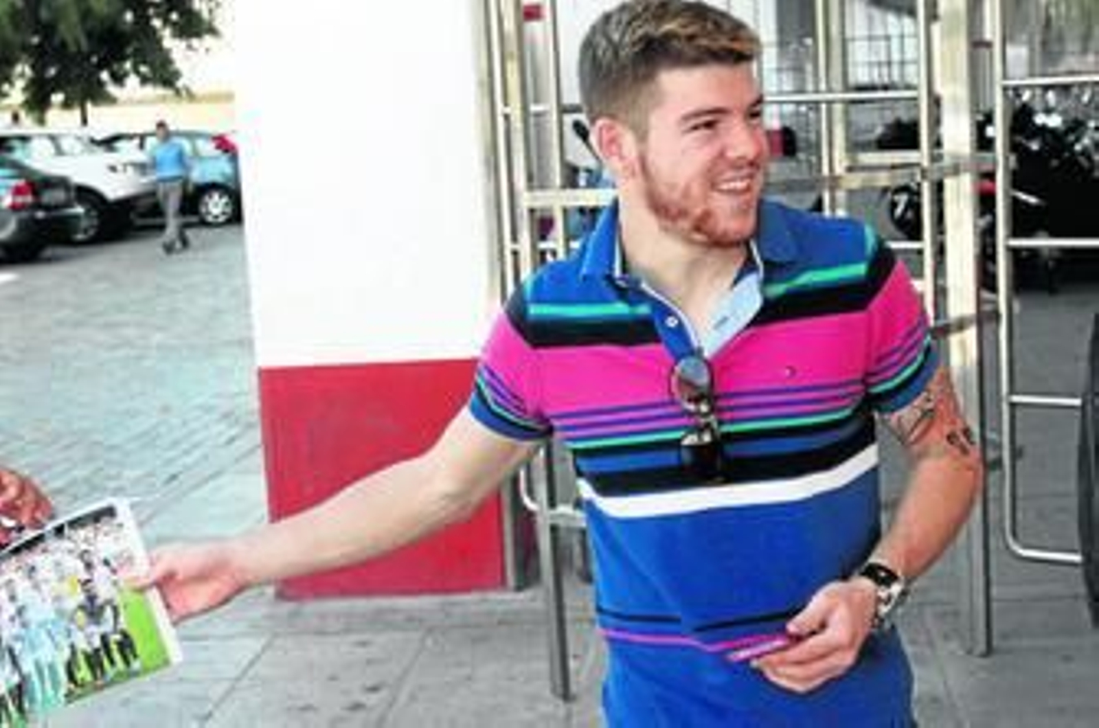Alberto Moreno firma un póster a un aficionado en las puertas del Ramón Sánchez-Pizjuán.