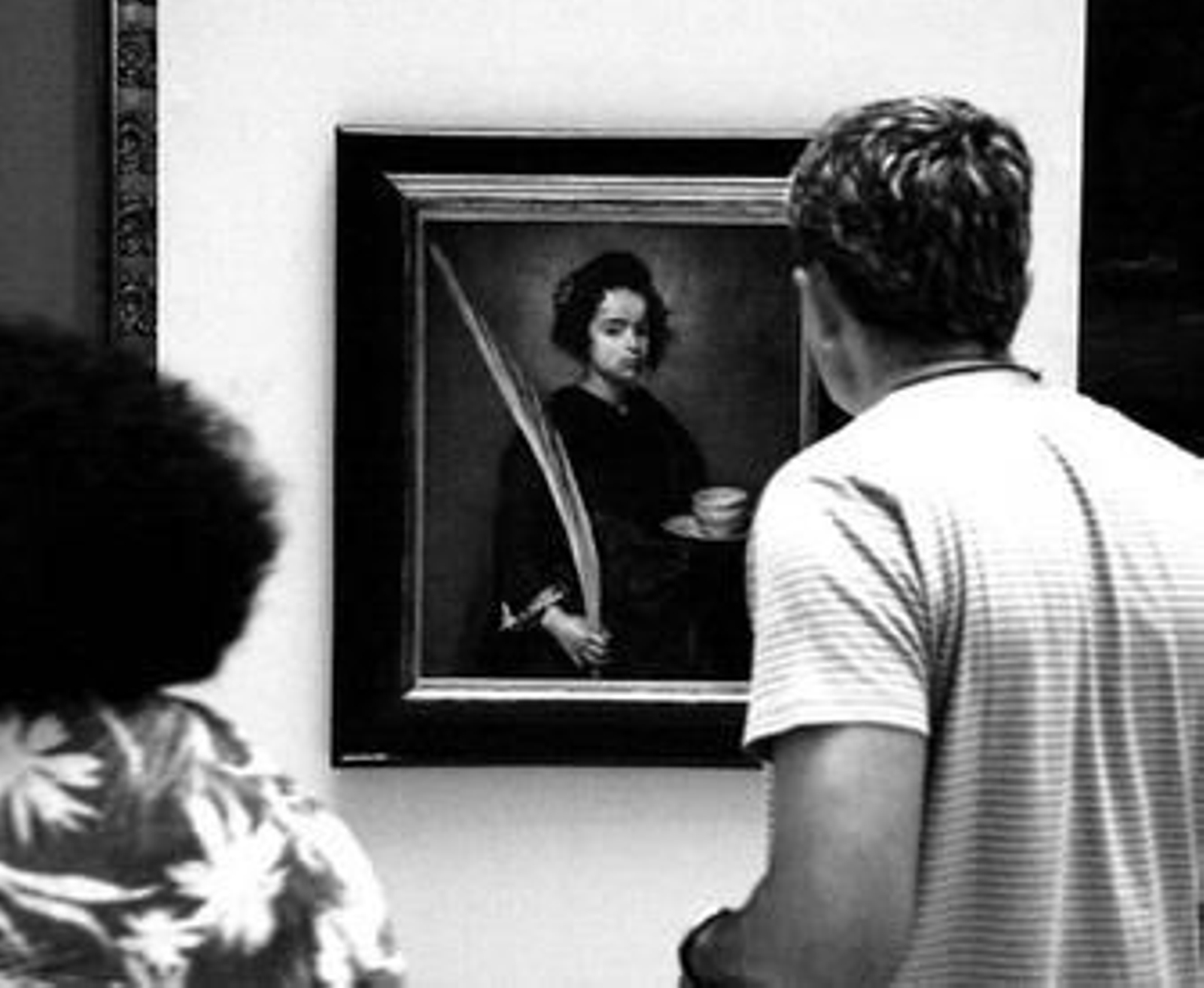 Dos espectadores contemplan el cuadro durante su paso temporal por el Ayuntamiento.