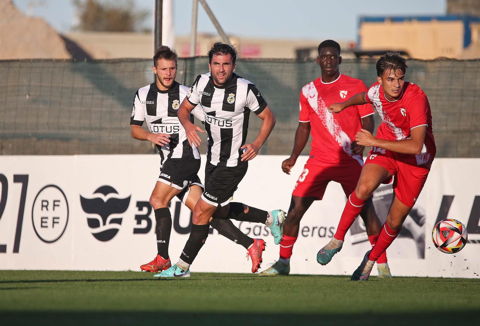 Lulo persigue un balón delante de Musa y un rival.