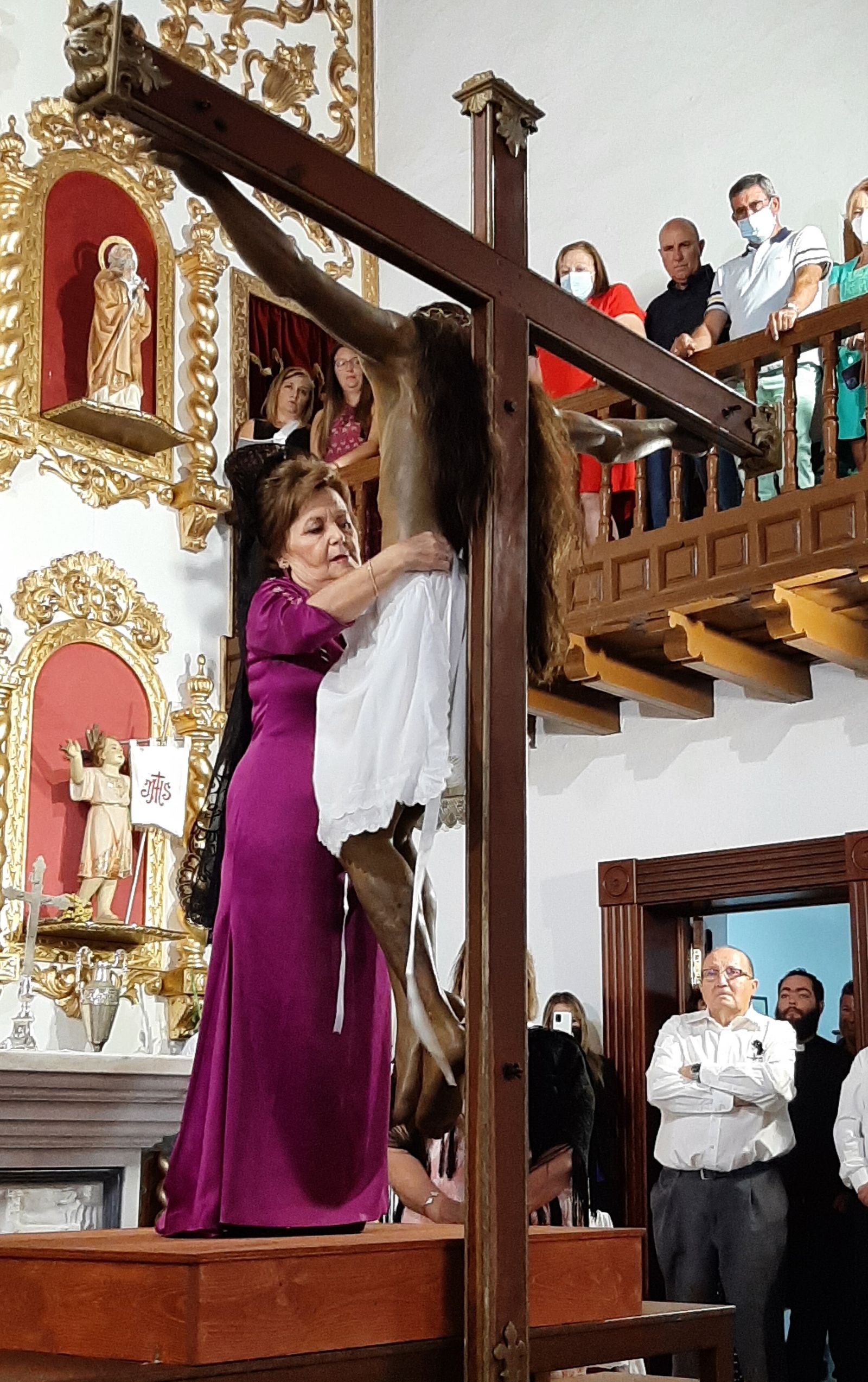 La camarera mayor cambia la vestidura al Santo Cristo del Bosque.