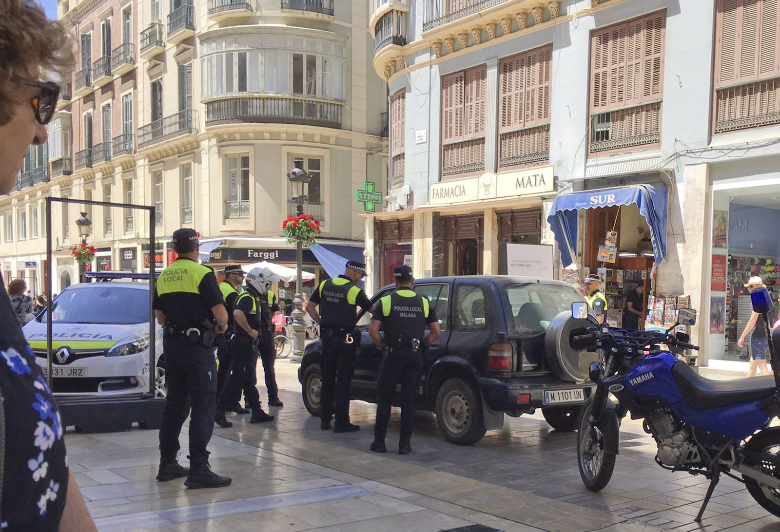 Varios policías rodean el vehículo que entró en calle Larios.